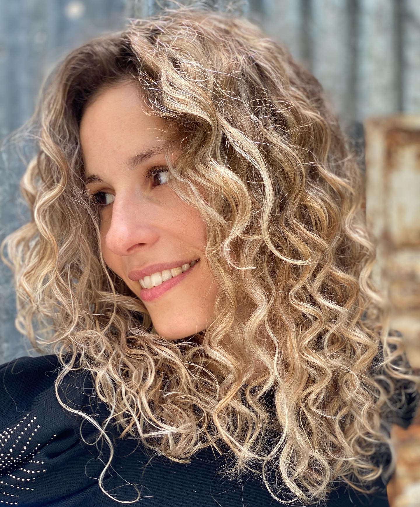 Textured Blonde Corkscrew Curls with Dark Roots