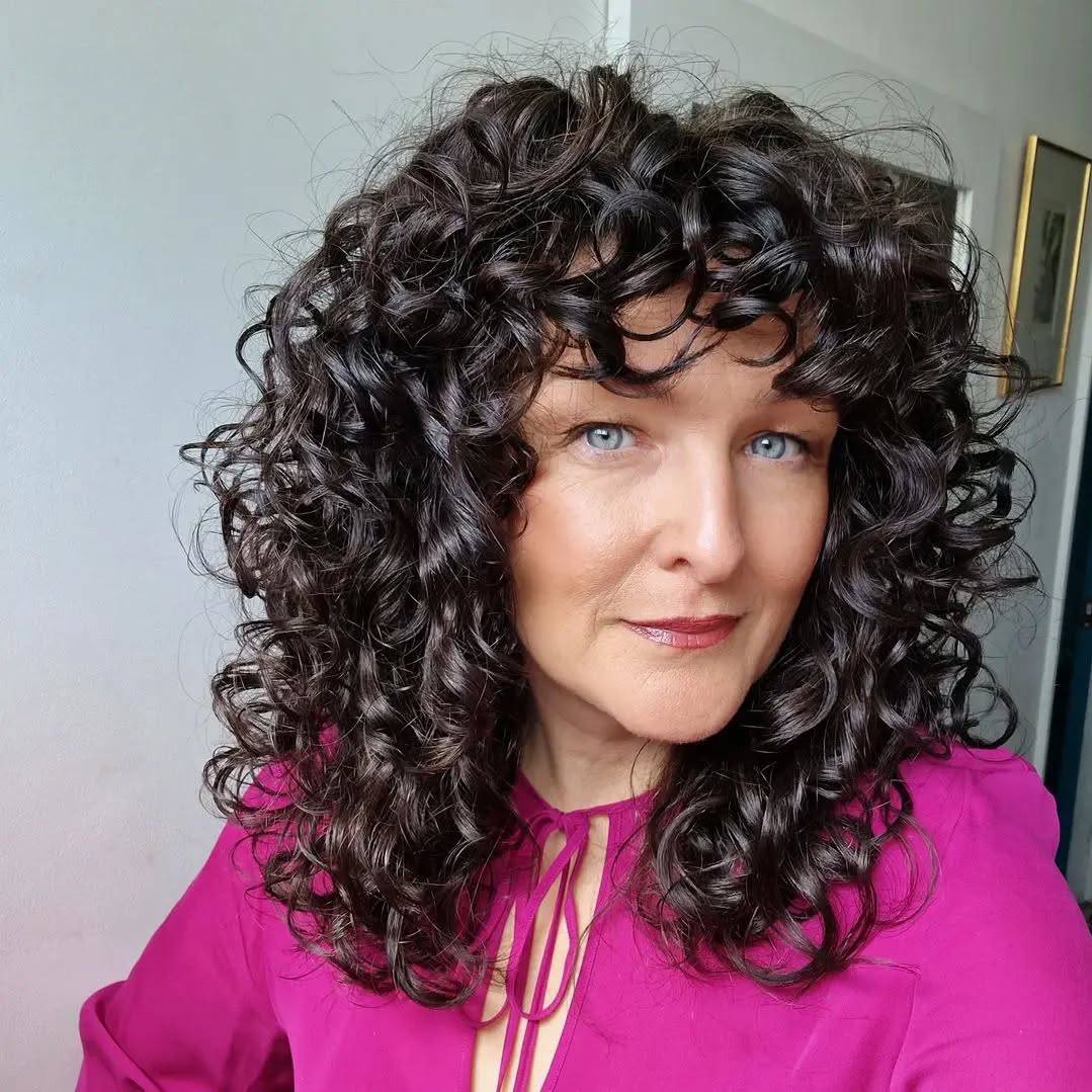 Bold Curly Face-Framing Layers with Defined Bangs