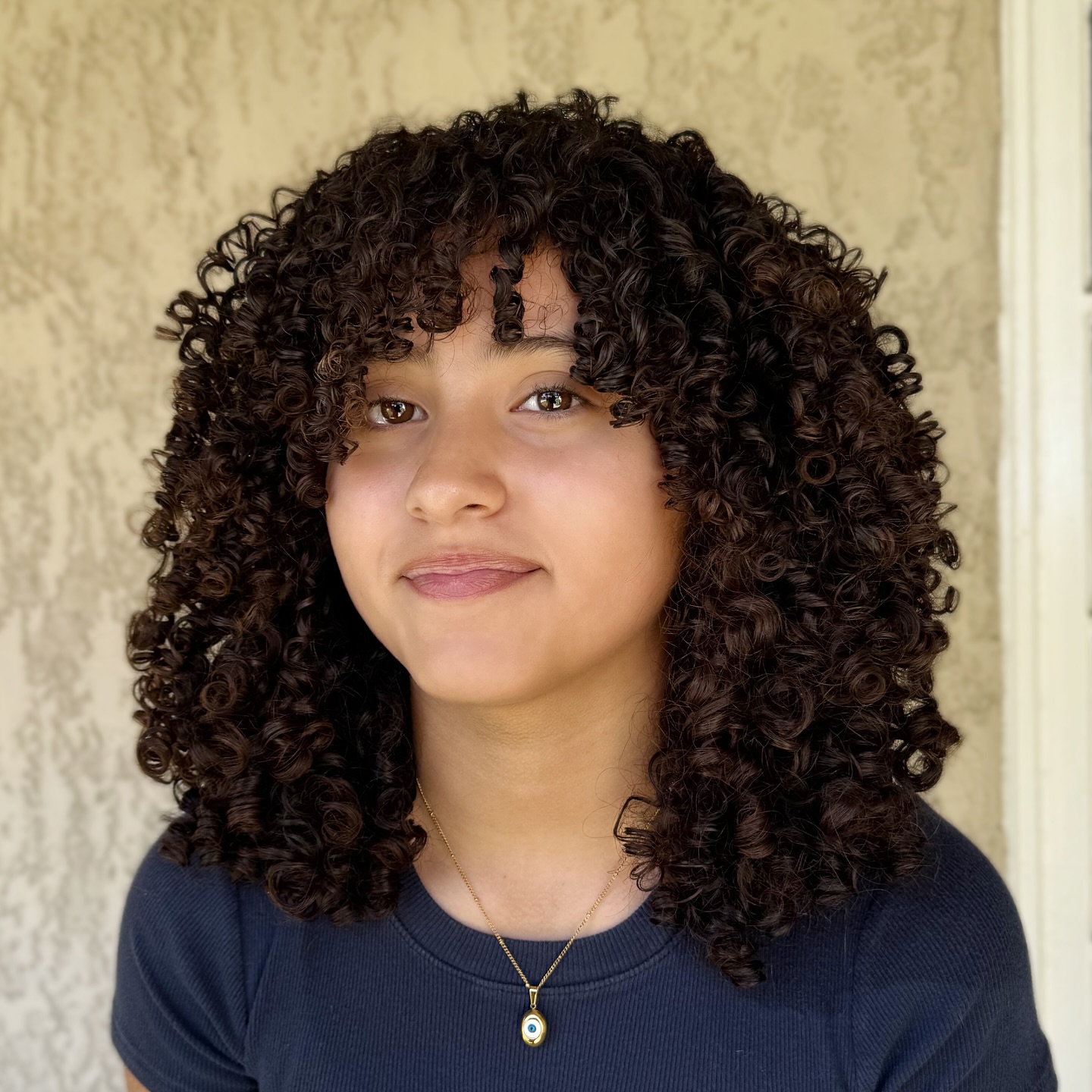 Playful Curly Face-Framing Shag with Defined Bangs