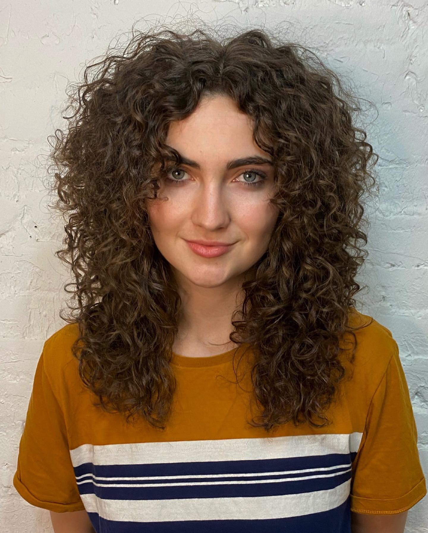 Dynamic Shoulder-Length Curly Wolf Cut with Natural Highlights