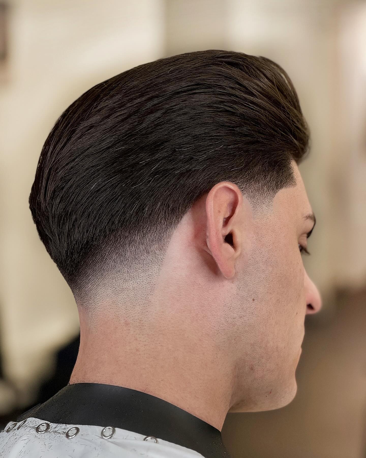 Sleek Combed-Over Pompadour with Sharp Fade