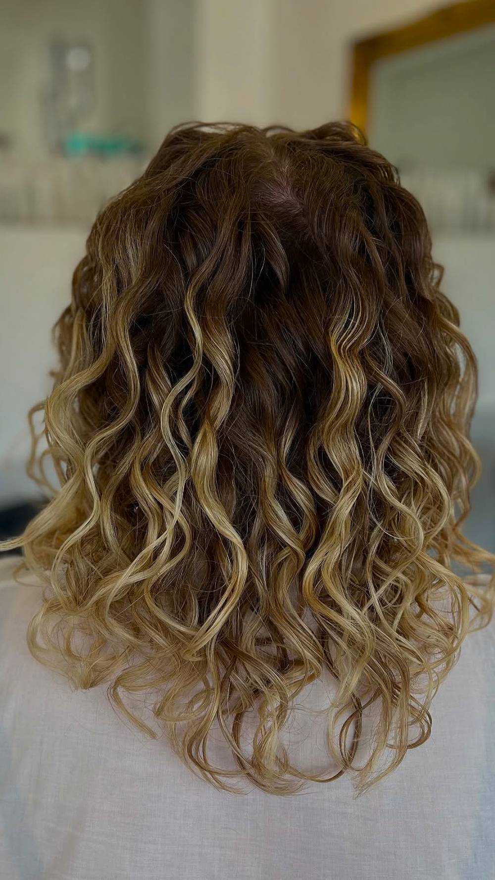 Charming Soft Curly Lob with Sun-Kissed Highlights