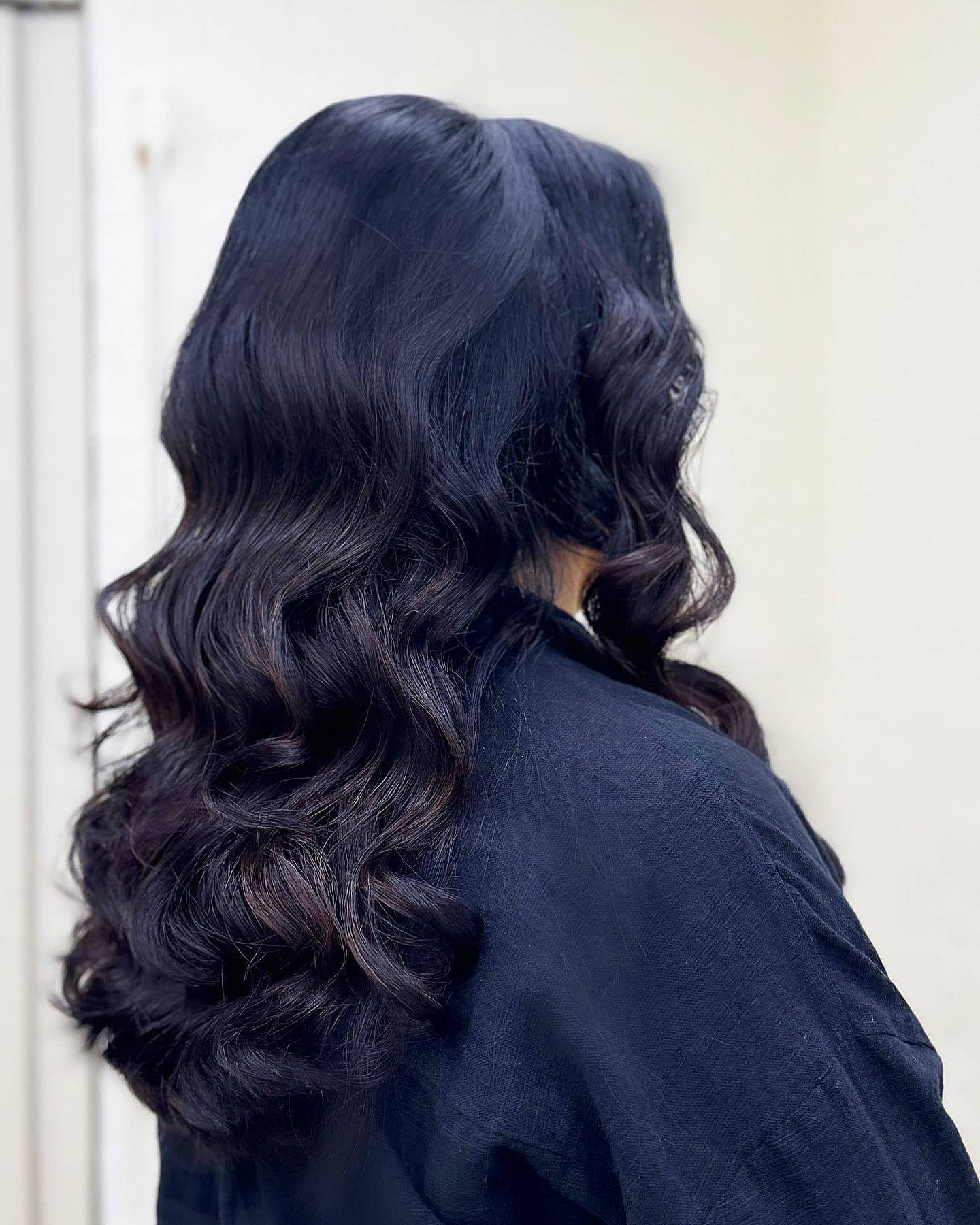 Glossy Dark Wavy Medium Length Hair with Defined Curls