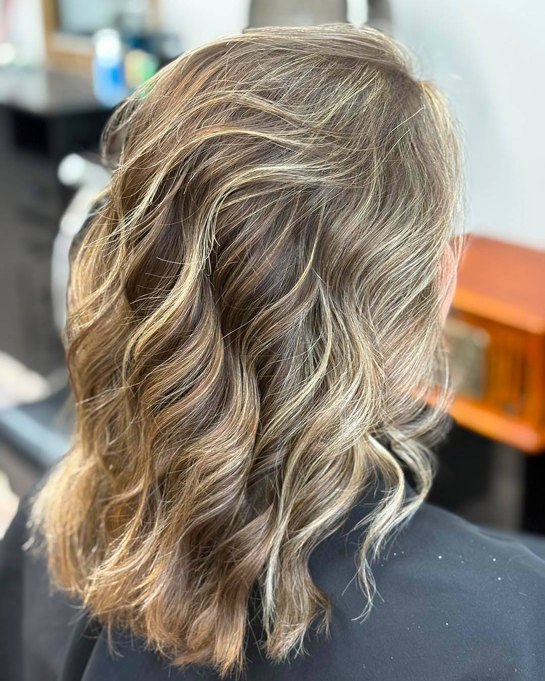 Softly Textured Medium Length Wavy Cut with Bright Highlights