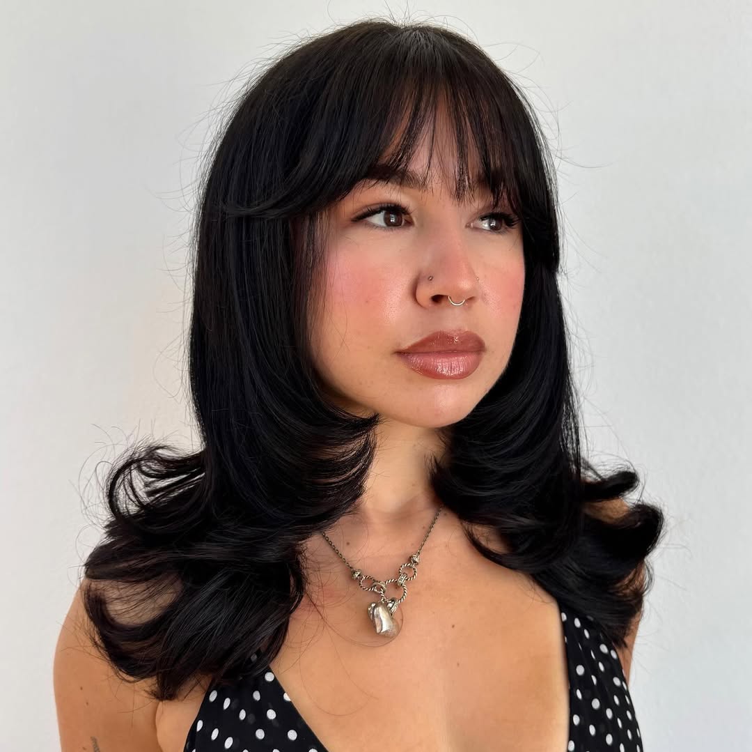 Sleek Black Cascading Curls with Full Bangs