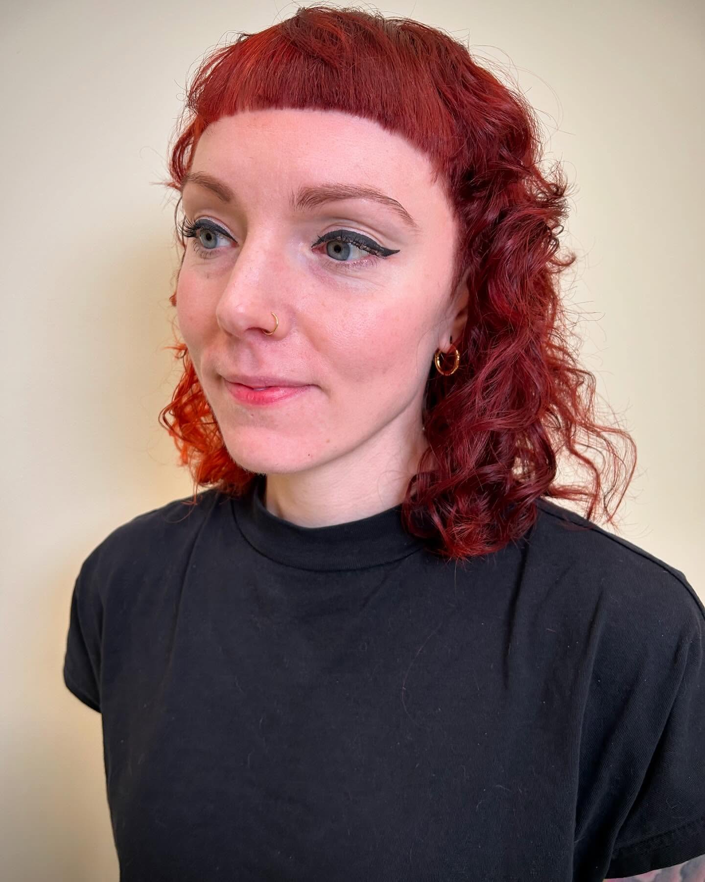 Bold Auburn Curly Bob with Straight Bangs