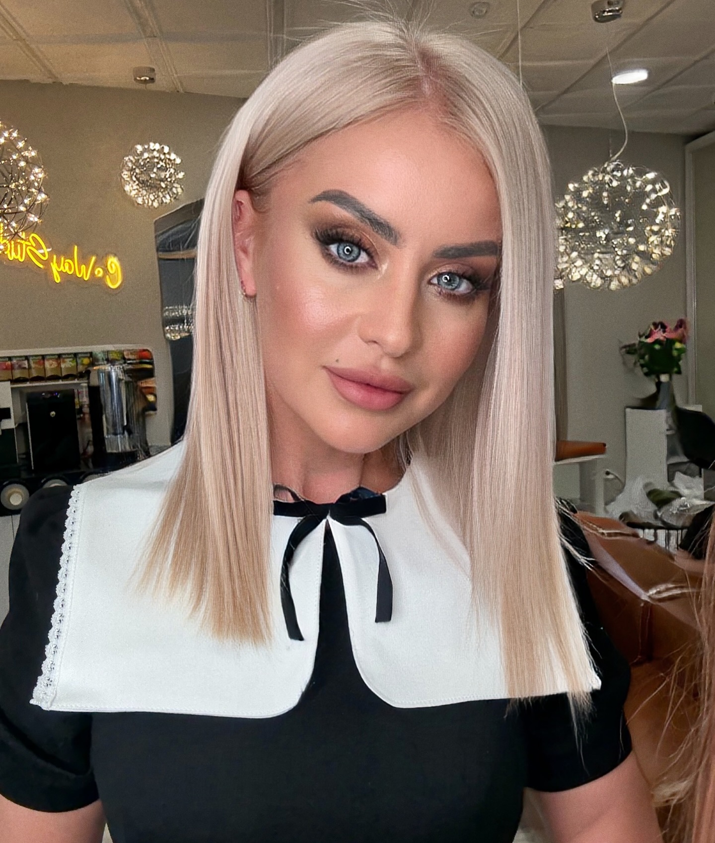 Glatter, platinblonder Lob mit schwarzer Schleife