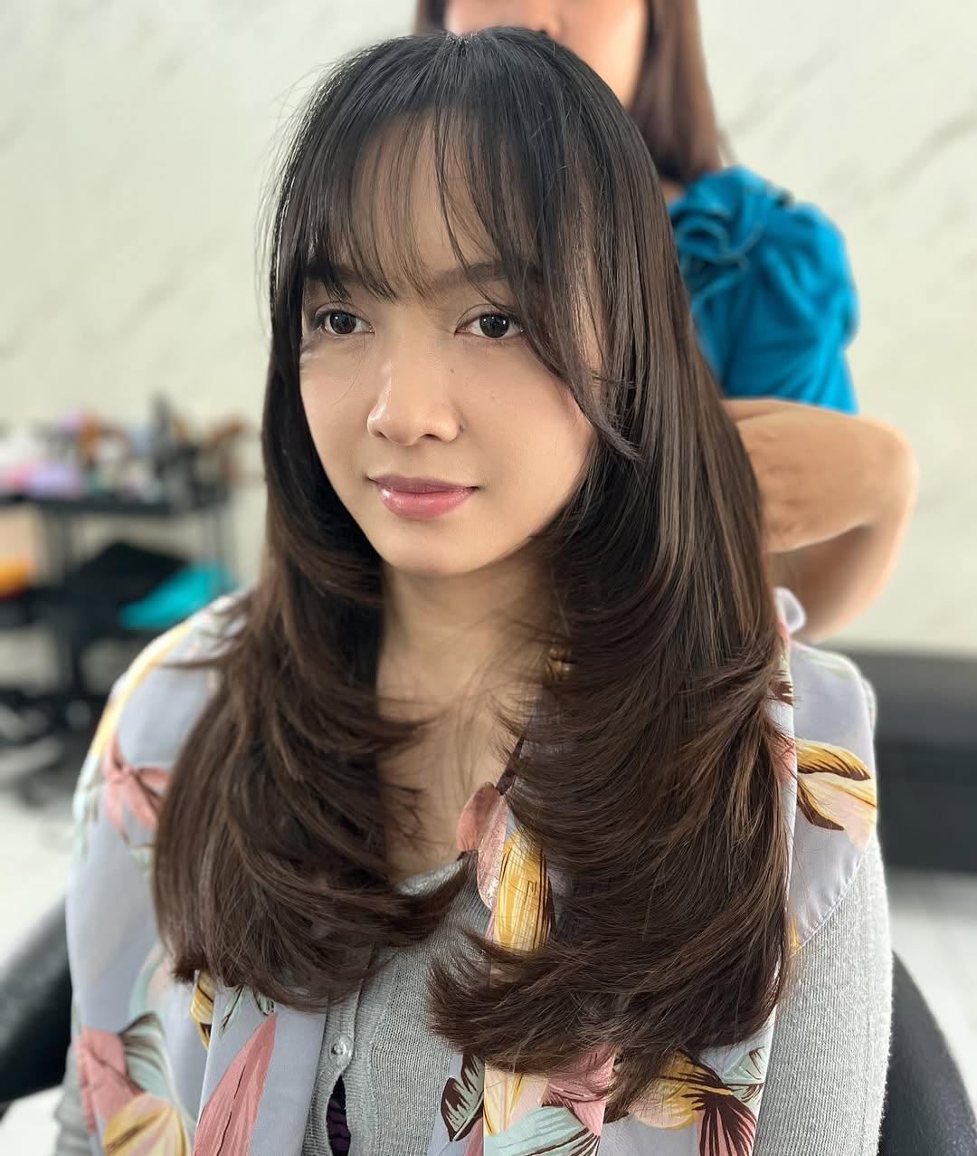 Cabelo castanho em camadas com franja suave e desfiada.