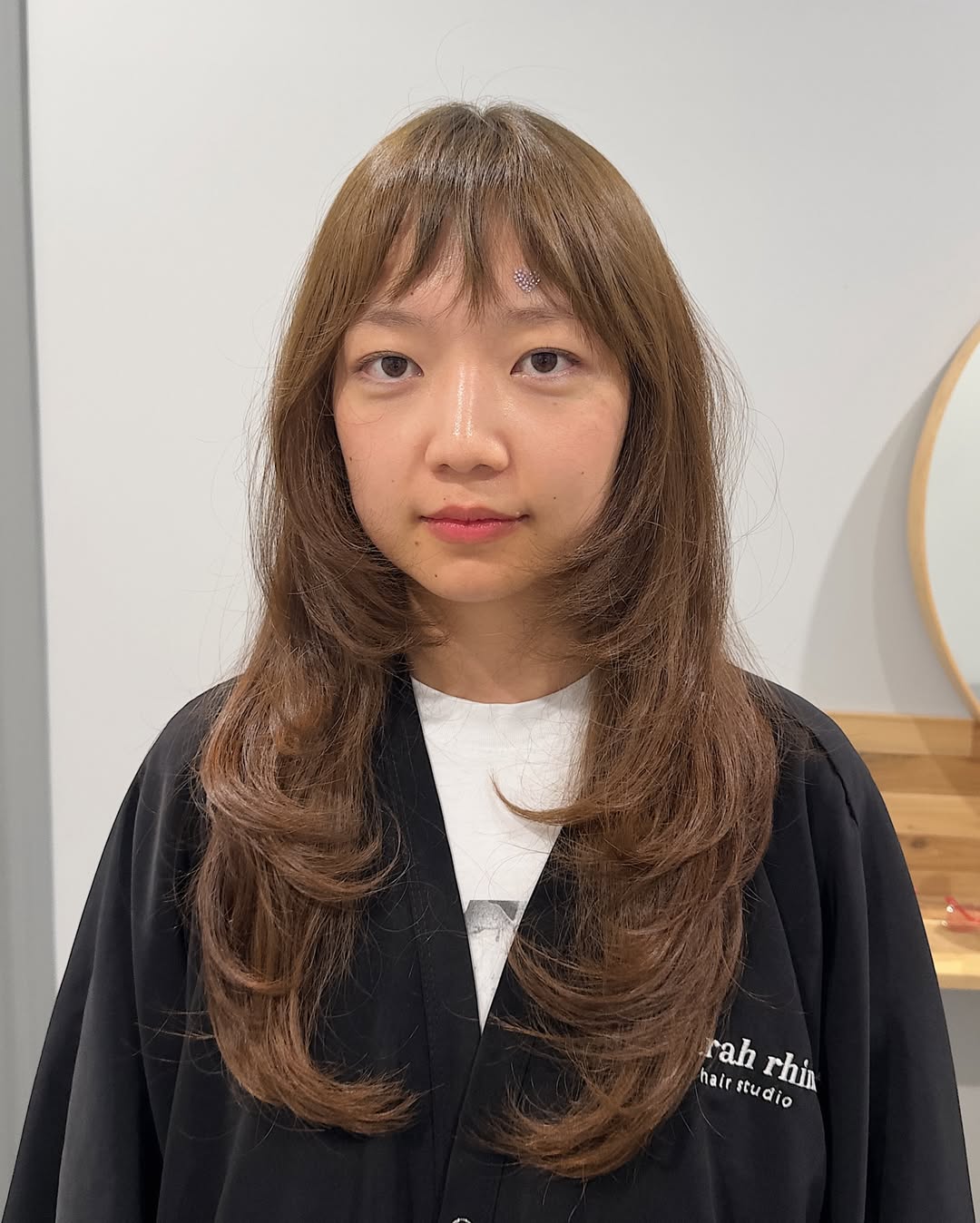 Balayage em tons de caramelo quente com franja leve e desfiada.