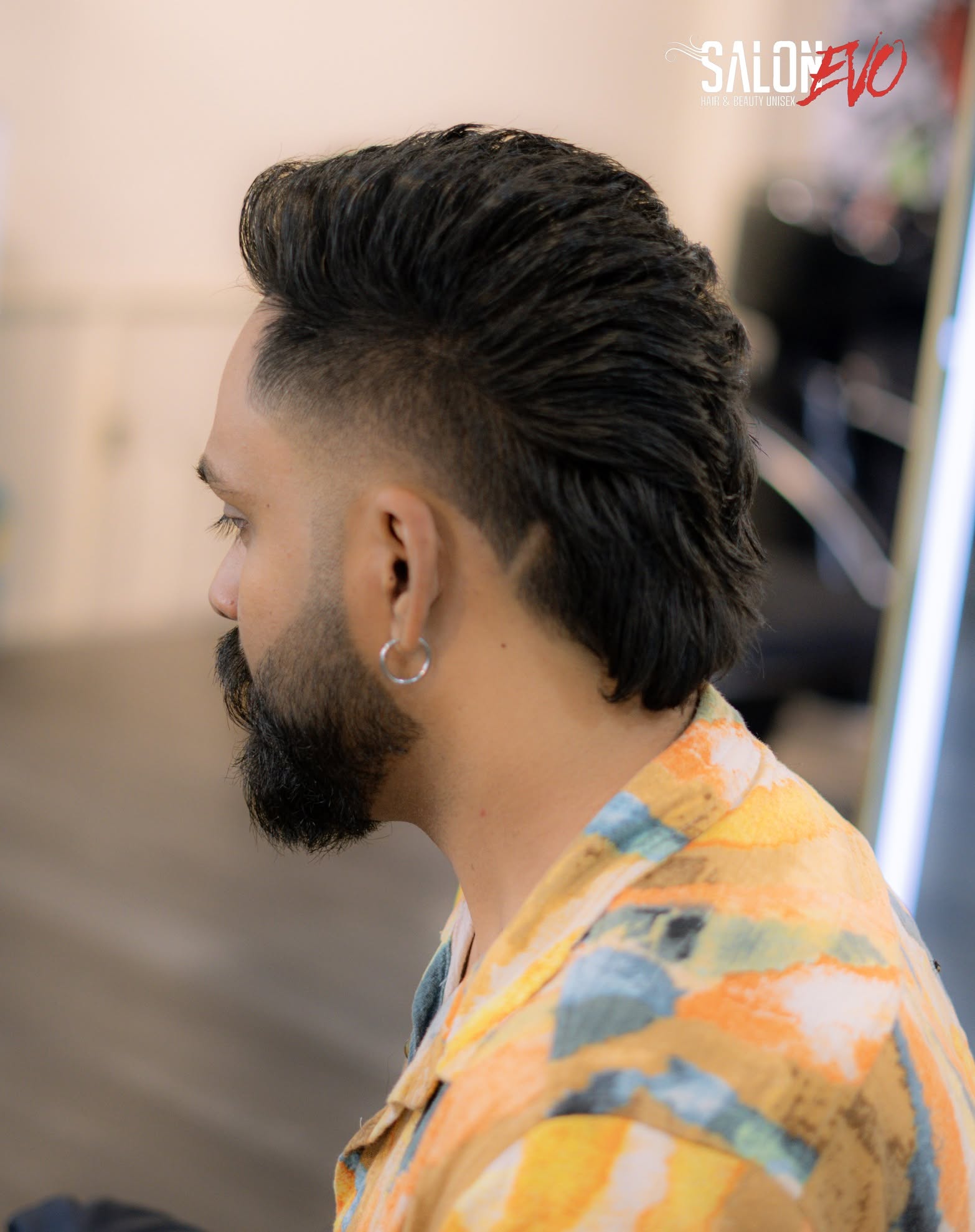 Kräftige, voluminöse Pompadour-Frisur mit spitz zulaufenden Seiten