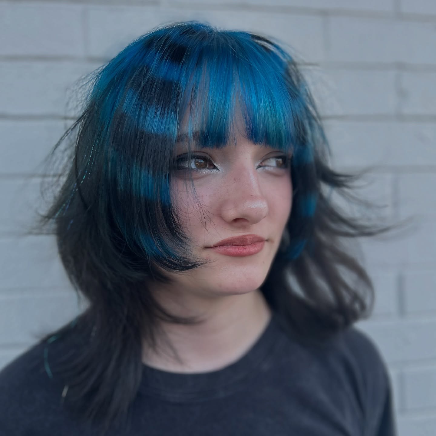 Bob despenteado chique em tons de azul e preto com franja chamativa.