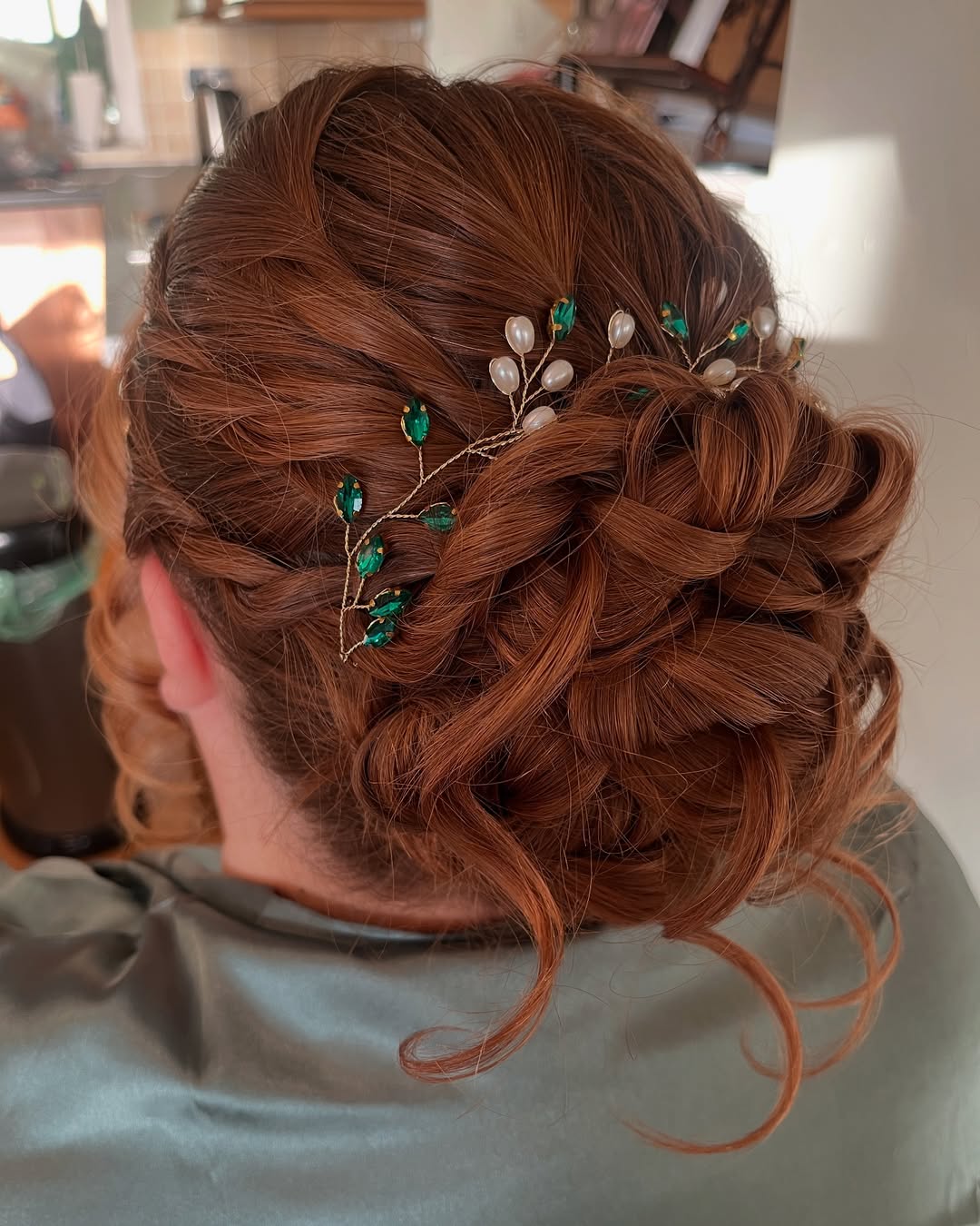 Penteado opulento com torções em tons de cobre e delicados acessórios para o cabelo.