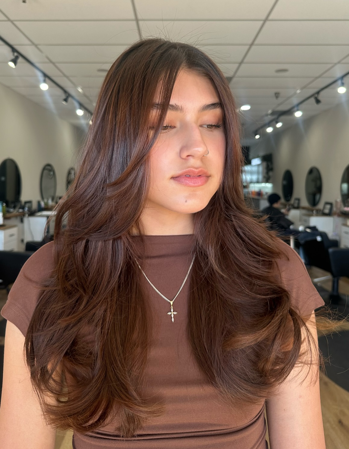 Ondas castanhas radiantes com mechas que emolduram o rosto.