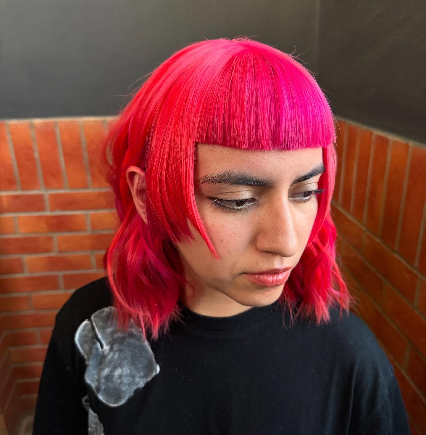 Corte bob rosa vibrante com franja precisa.