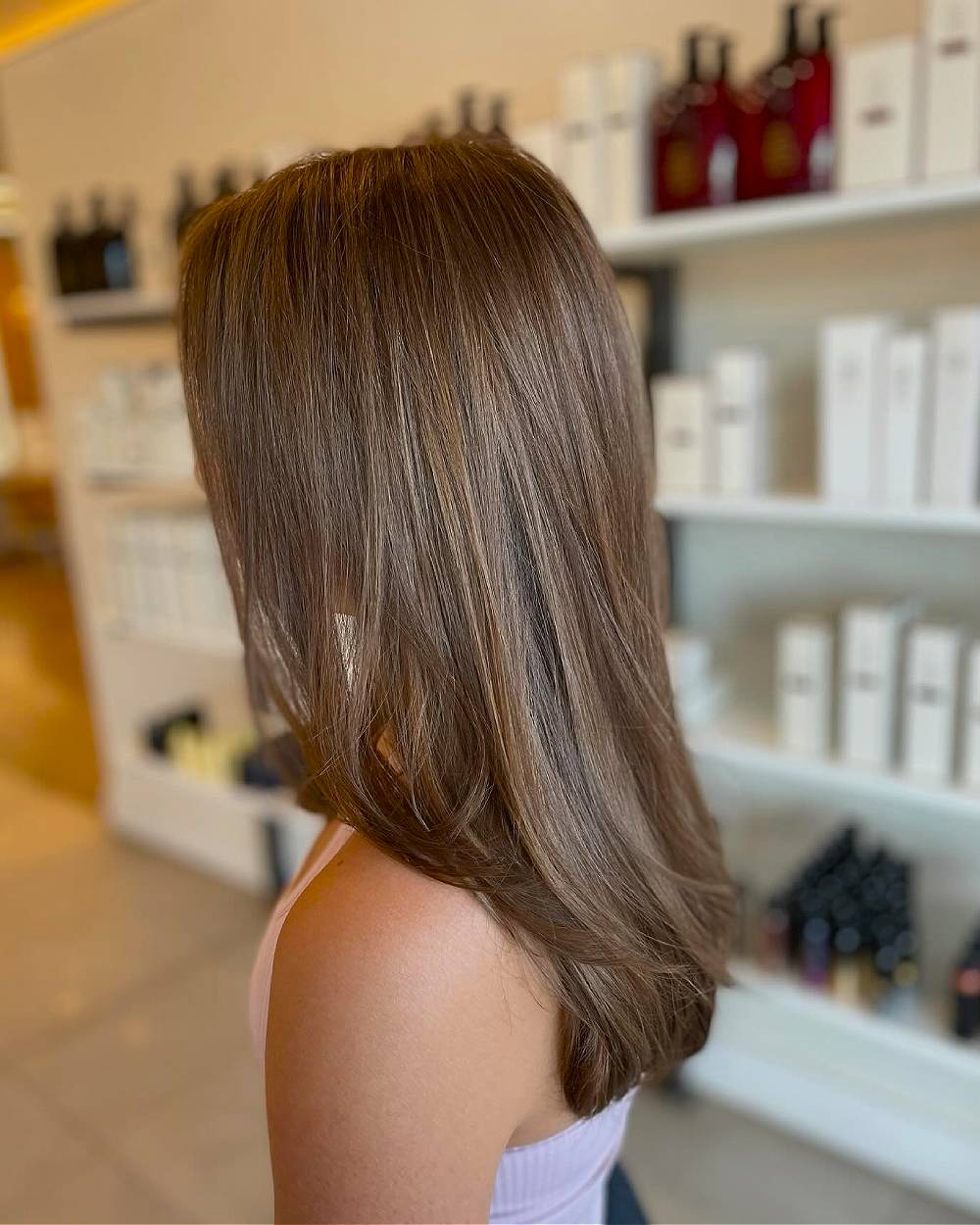 Capas clásicas largas de cabello castaño claro con sutiles reflejos