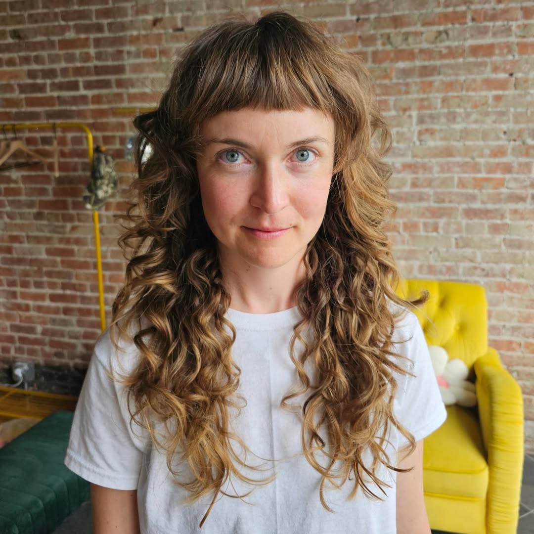 Curly Caramel Locks with Dramatic Baby Bangs