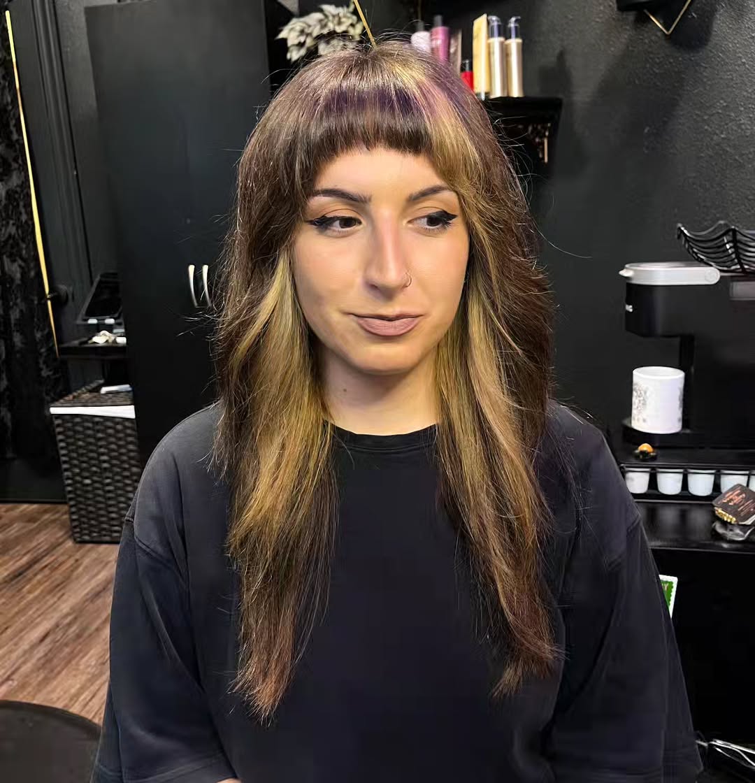 Long Layered Cut with Bold Baby Bangs and Purple Highlights