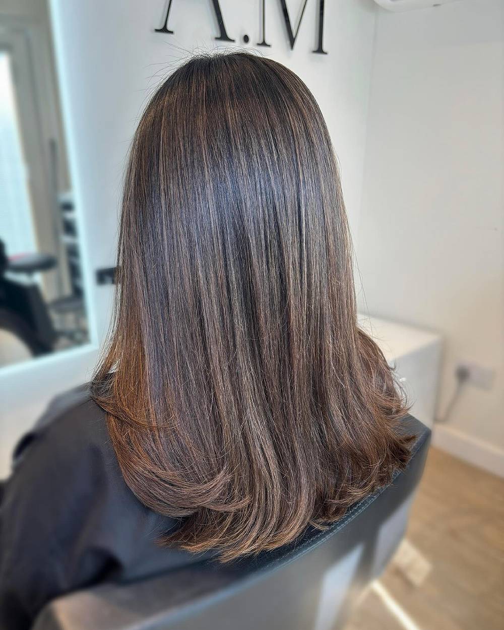 Capas largas y elegantes de cabello castaño con sutiles reflejos