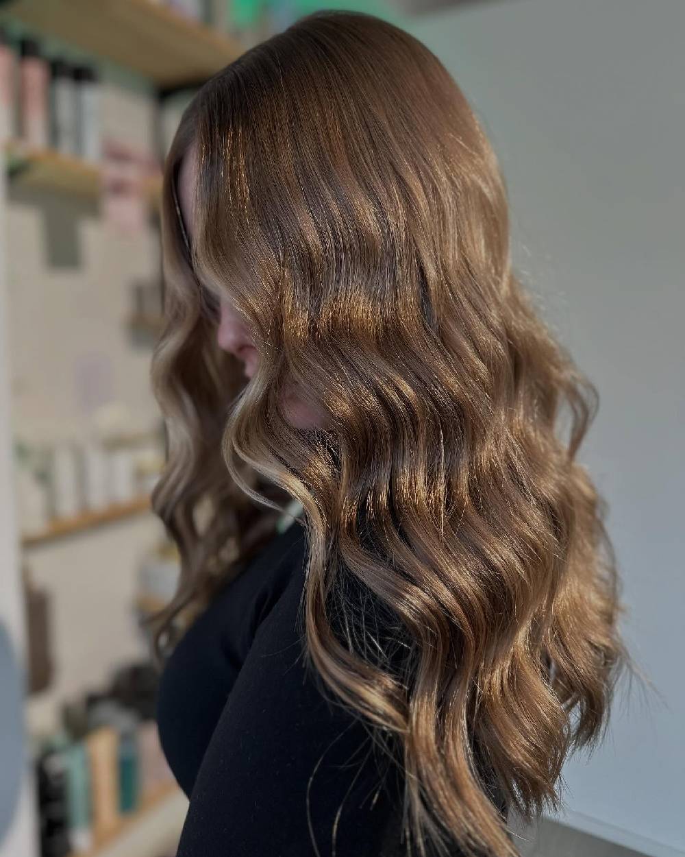Ondas voluminosas de cabello castaño claro con sutiles reflejos caramelo