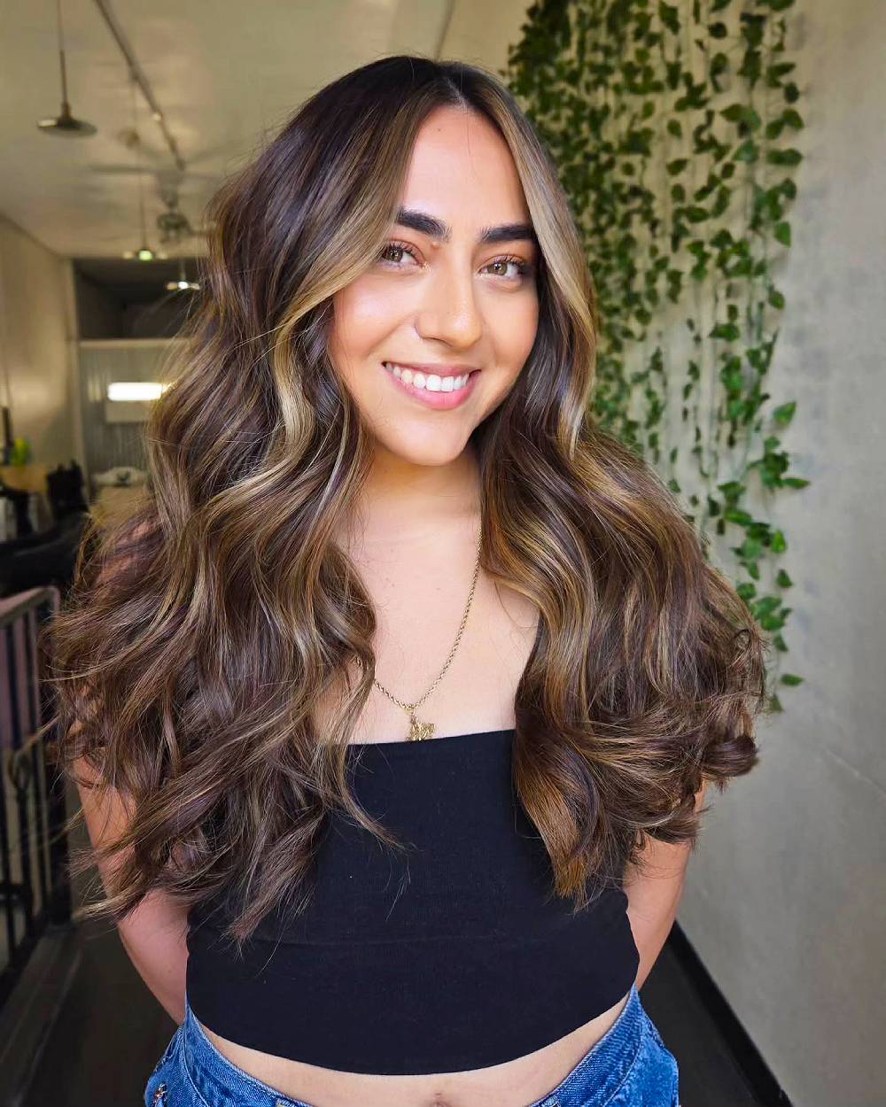 Ondas castañas cálidas con reflejos que enmarcan el rostro