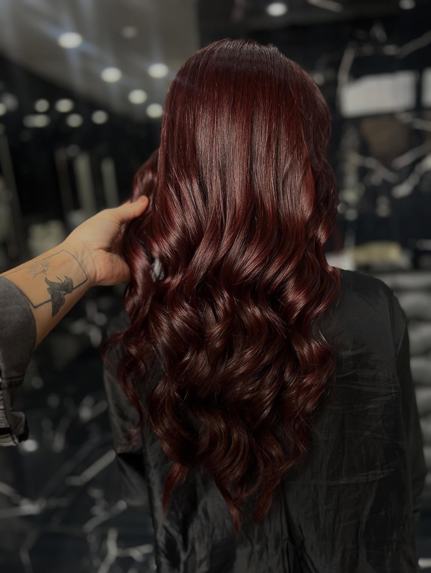 Glänzende purpurrote Wellen auf langen Locken