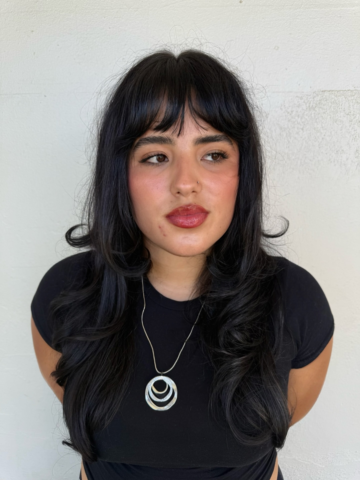 Deep Black Cascading Curls with Bold Bangs