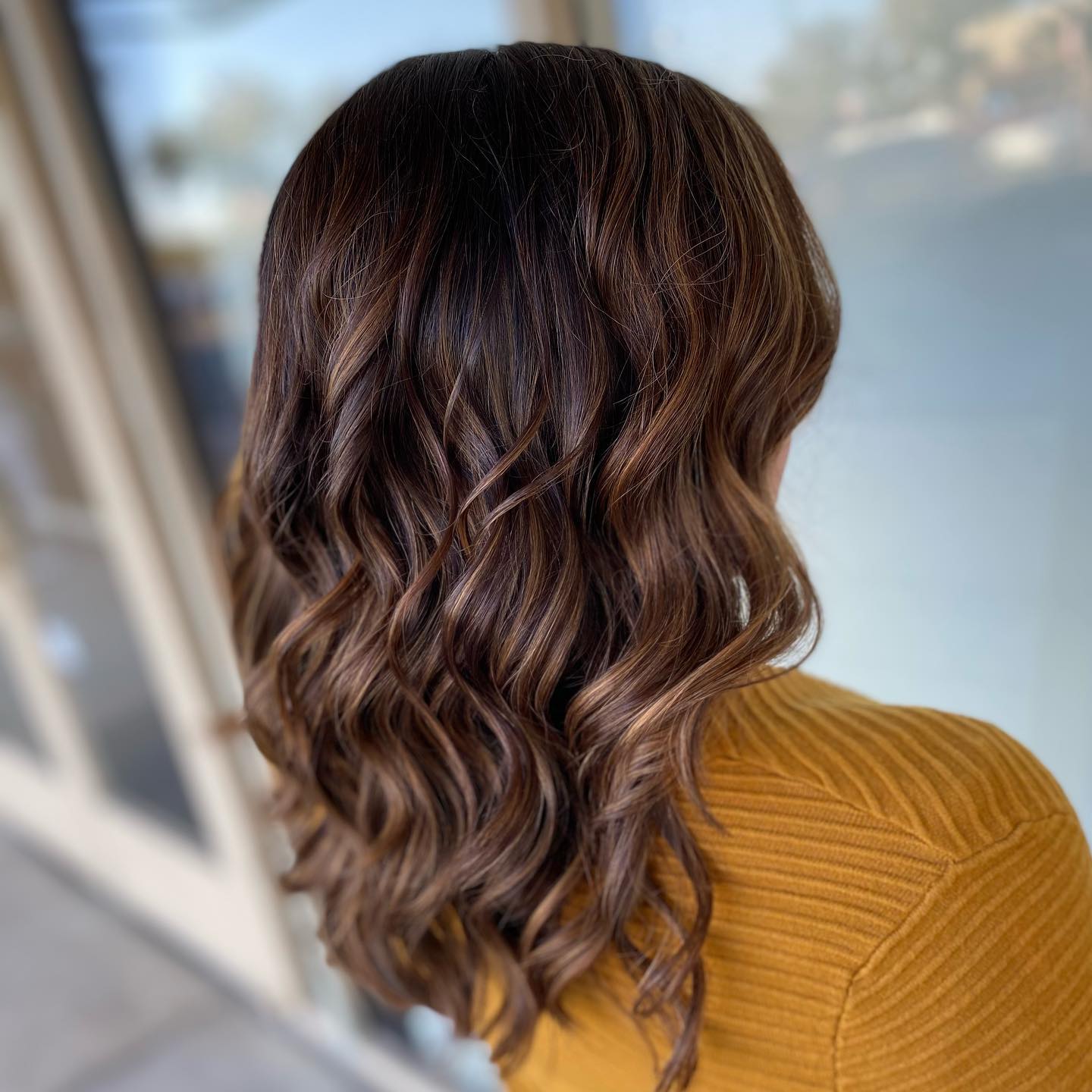 Warm Chestnut Curls with Luminous Highlights