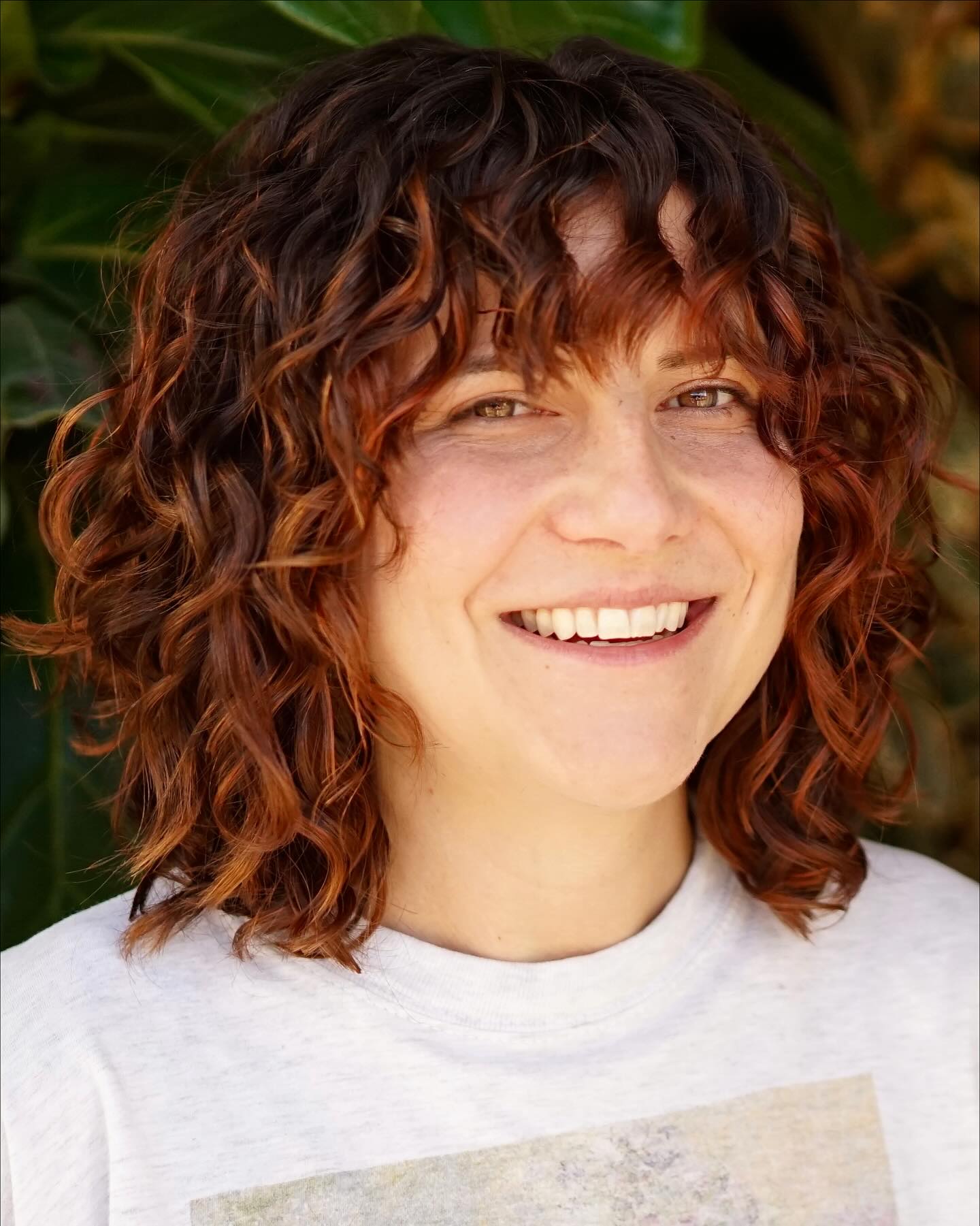 Playful Auburn Curly Bob with Natural Bangs