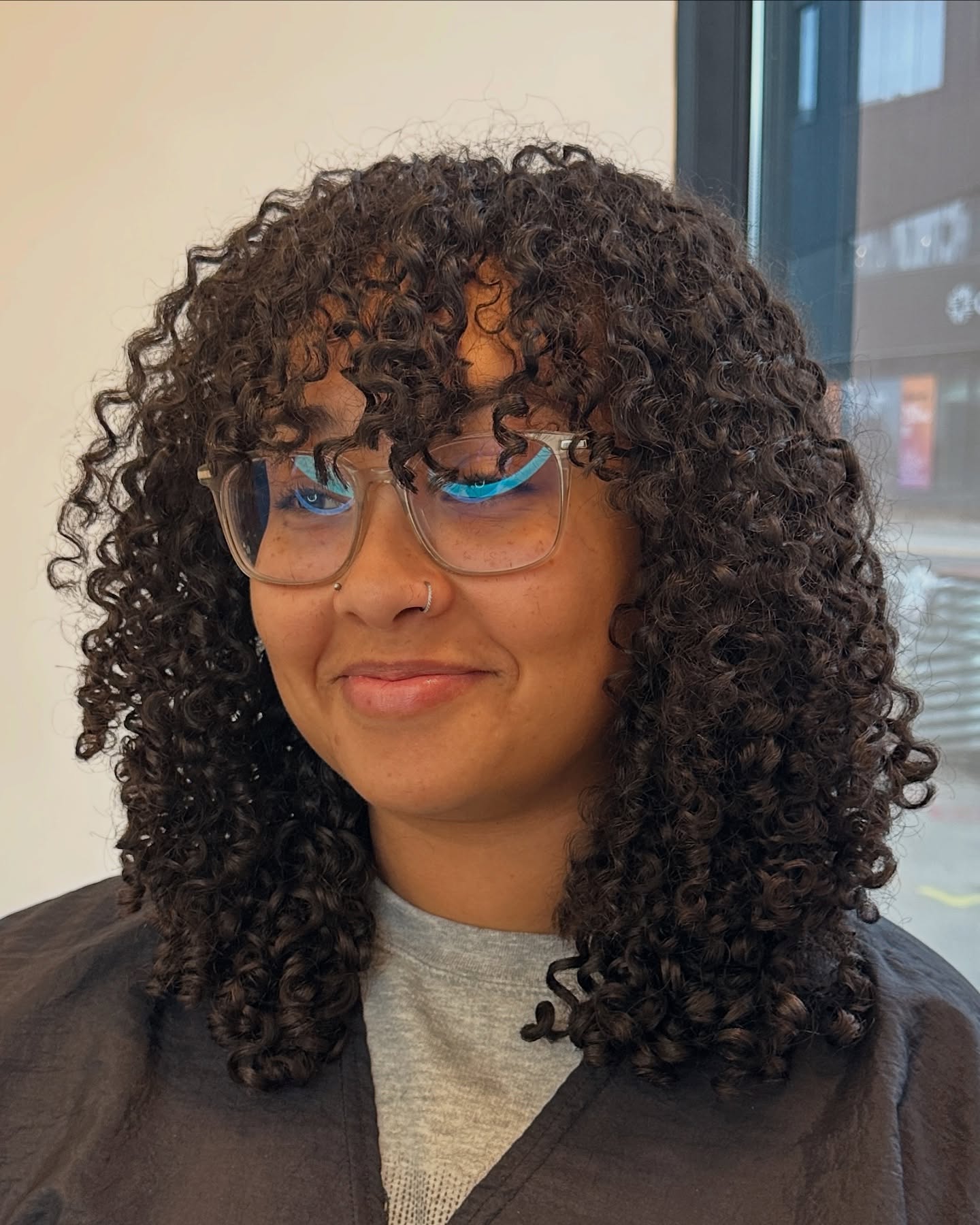 Chic Shoulder-Length Curly Cut with Defined Bangs