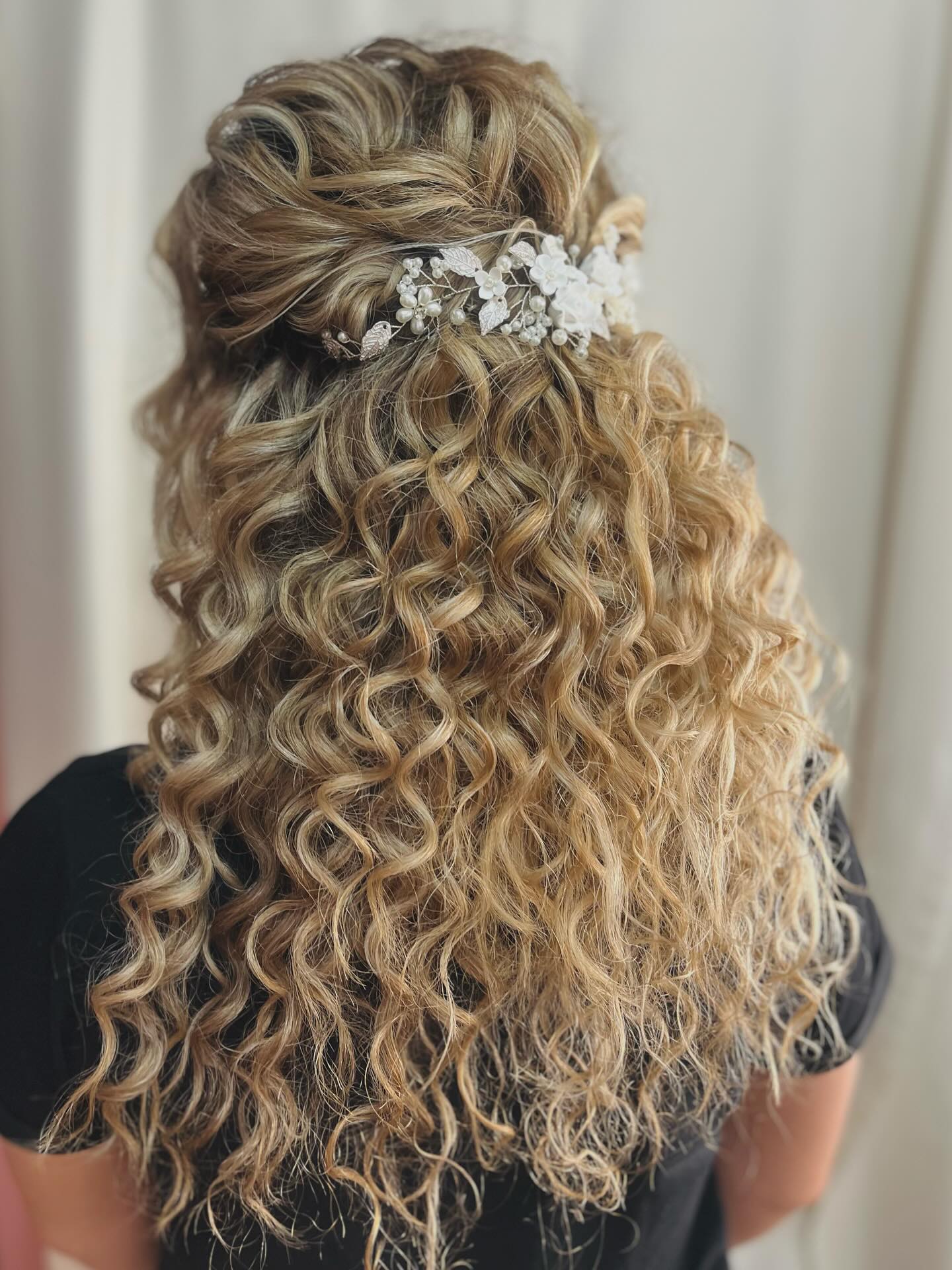 Captivating Voluminous Curly Half Up Style with Floral Adornments