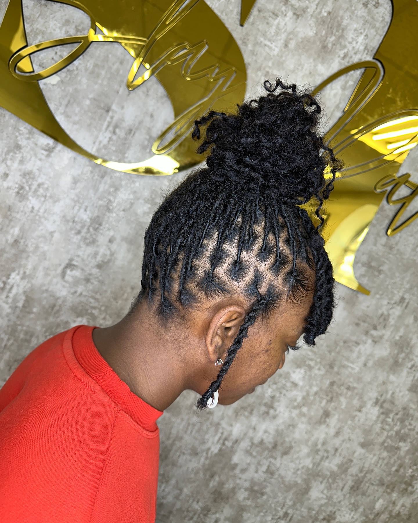 Textured High Bun Dreadlock Style with Face-Framing Strands
