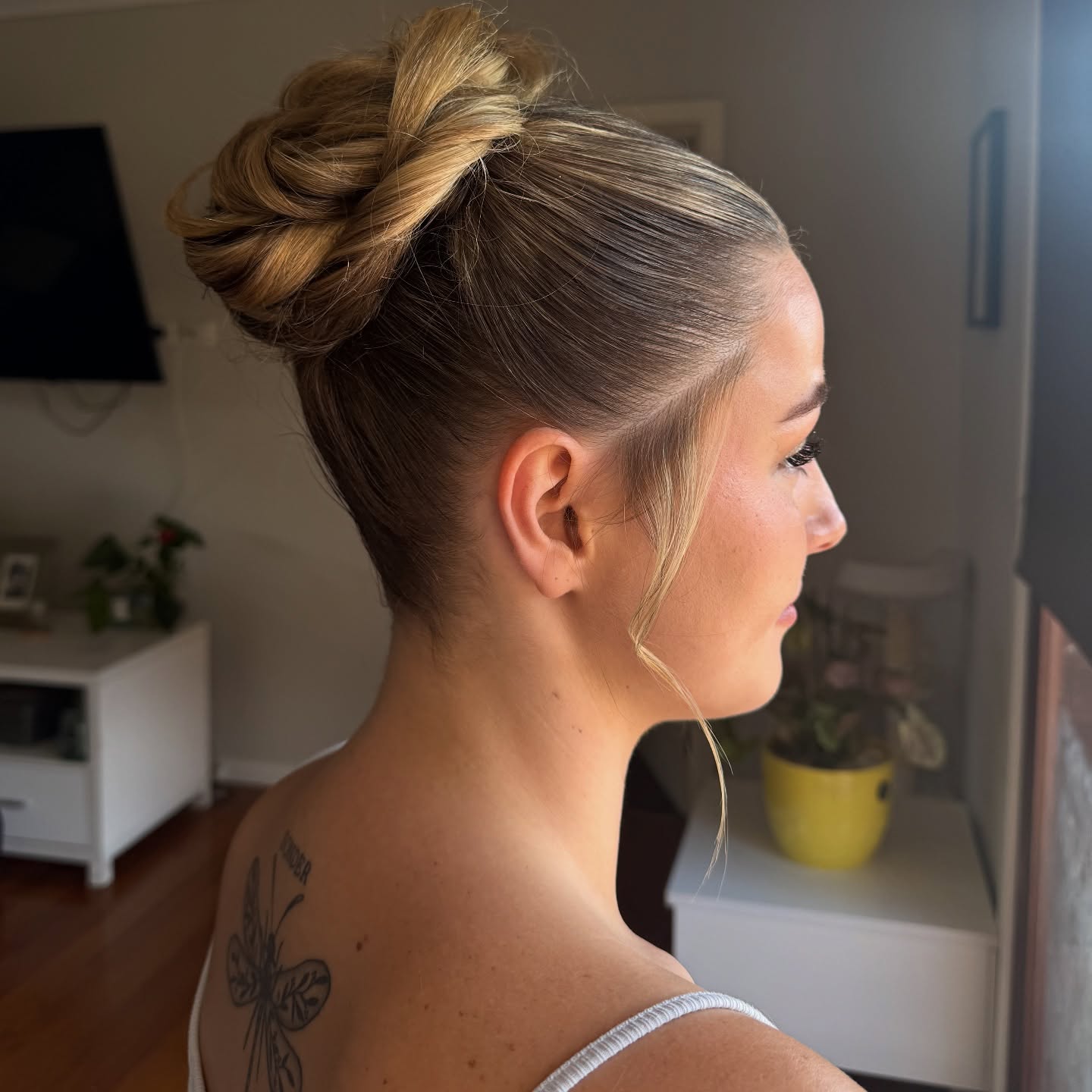 Textured High Bun with Face-Framing Tendrils