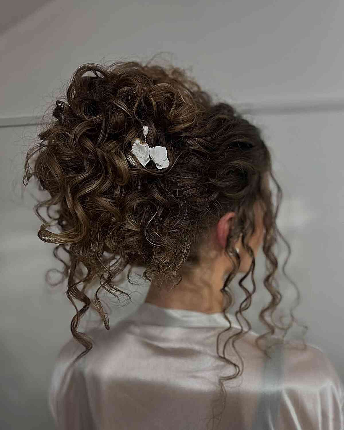 Elegant Curly Updo with Floral Accents