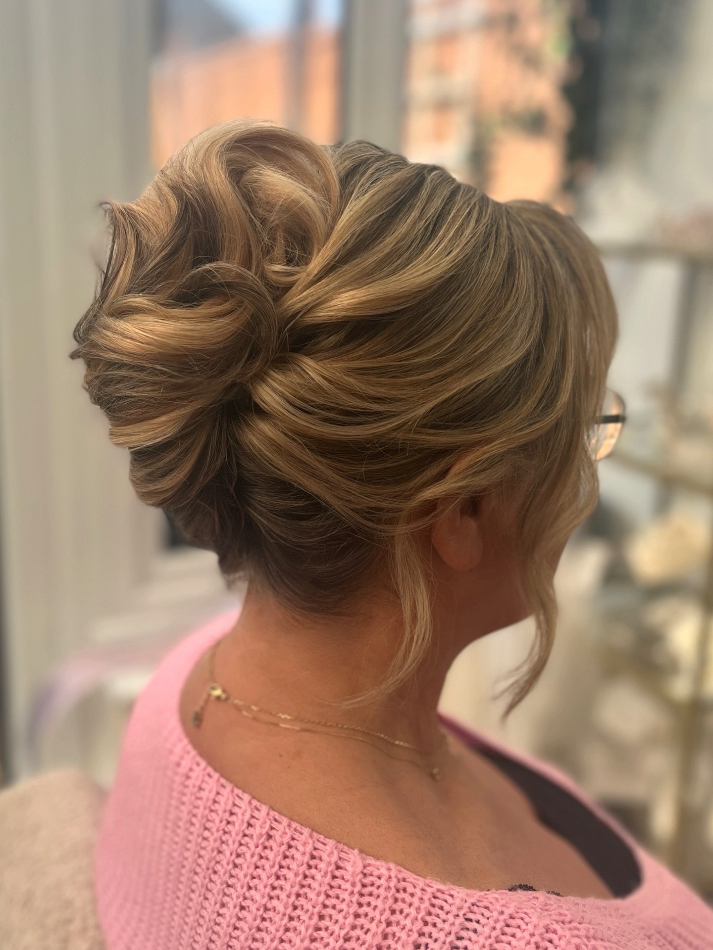 Looped Low Chignon with Painted Lowlights and Face-Framing Tendrils