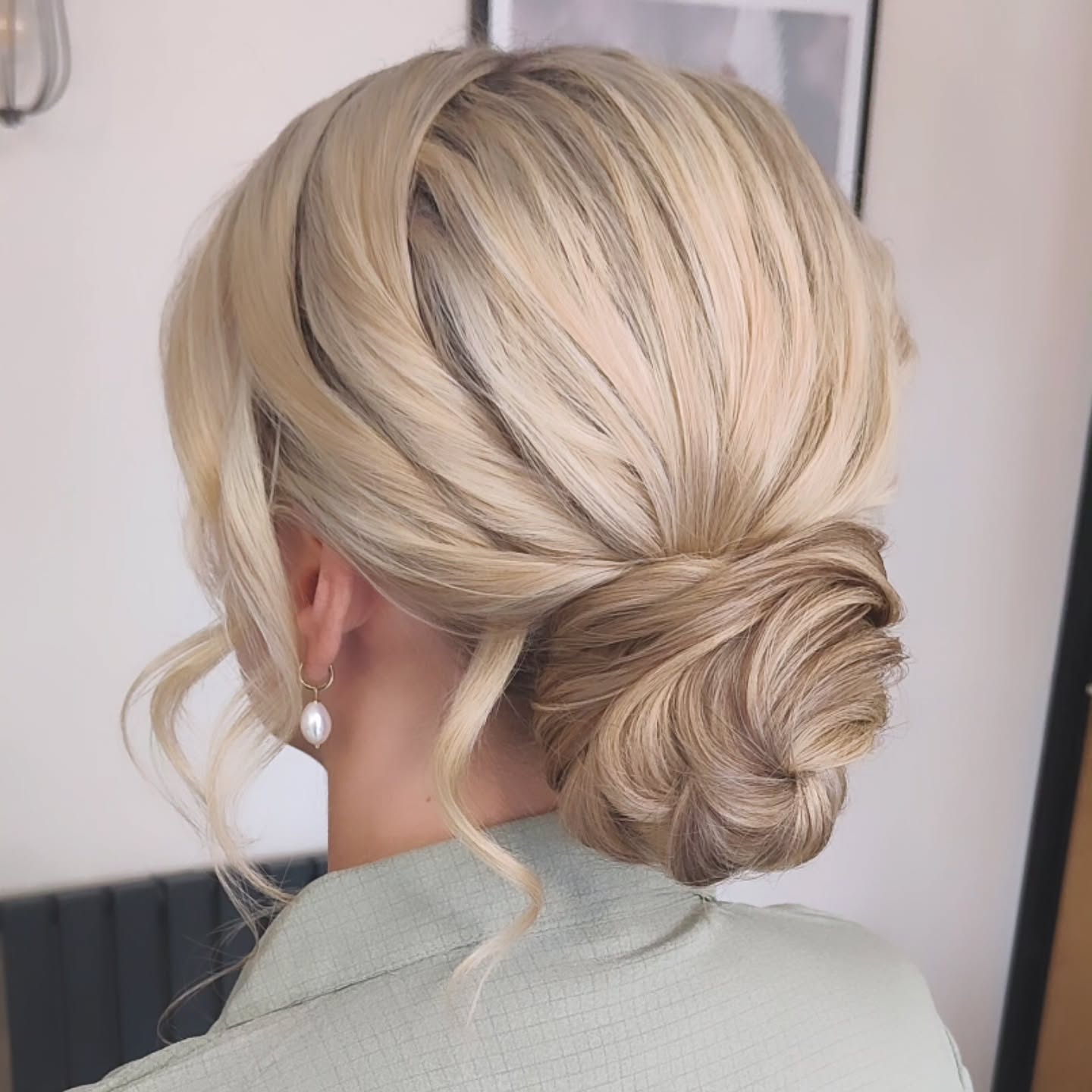 Low Twisted Chignon with Root Shadow and Face-Framing Tendrils