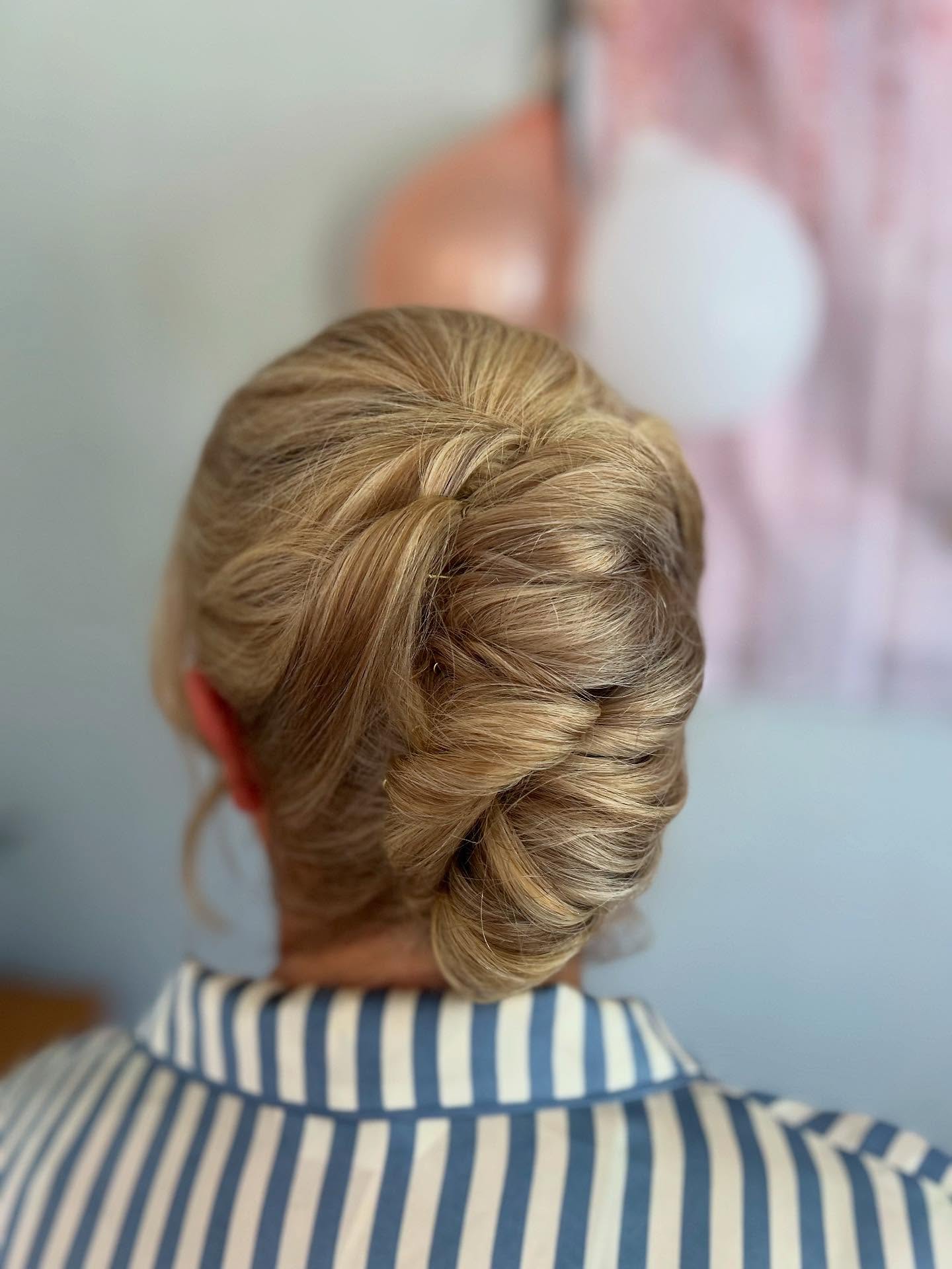 Rolled Vertical Twist Low Chignon with Soft Face-Framing Tendrils