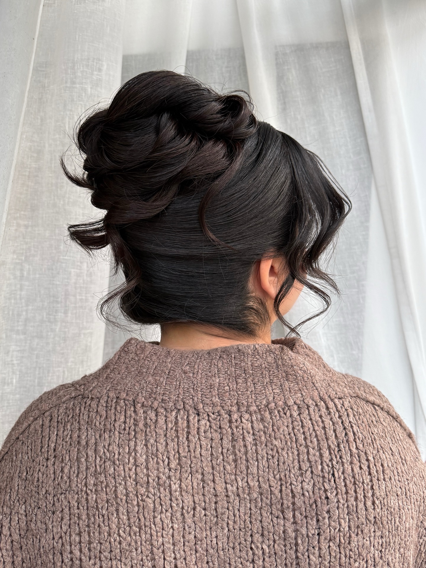 Sculpted Twisted High Bun with Soft Face-Framing Tendrils