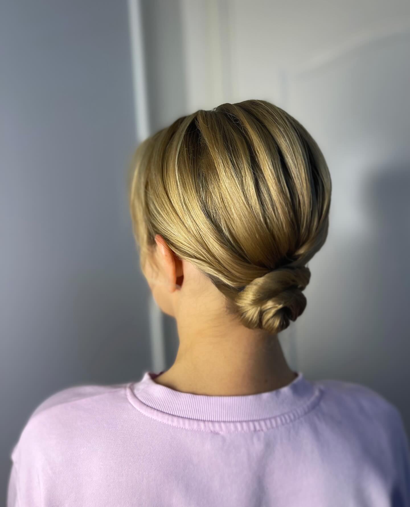 Sleek Low Twisted Bun with Subtle Root Shadow