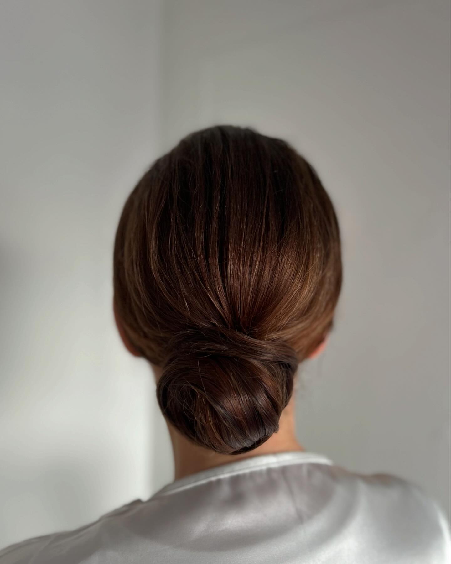 Sleek Low Twisted Chignon with Concealed Diagonal Wrap