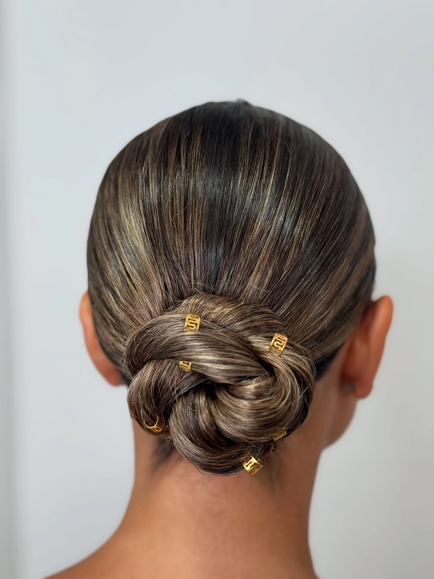 Sleek Twisted Low Knot with Gold Micro-Cuffs