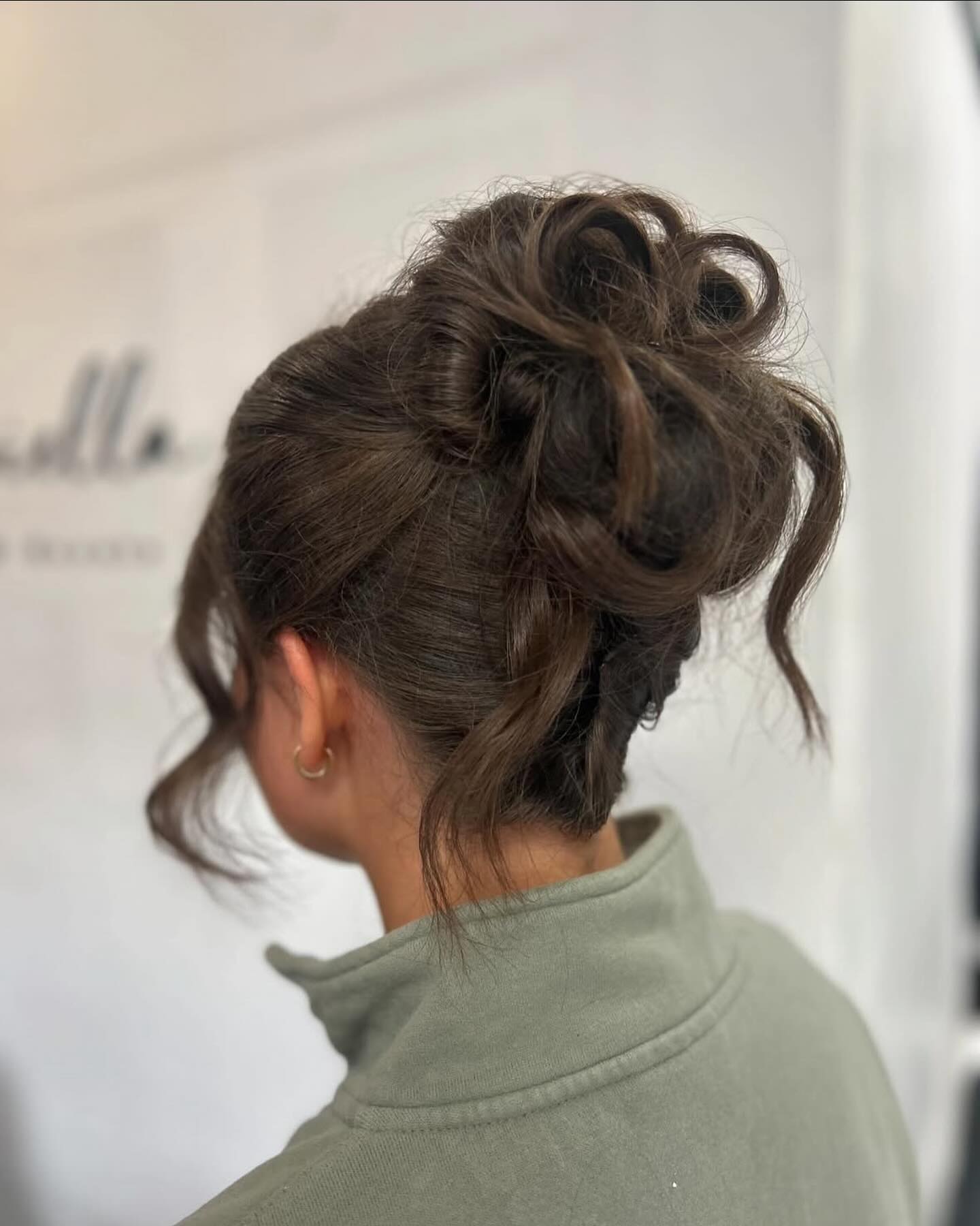 Textured High Knotted Updo with Face-Framing Tendrils