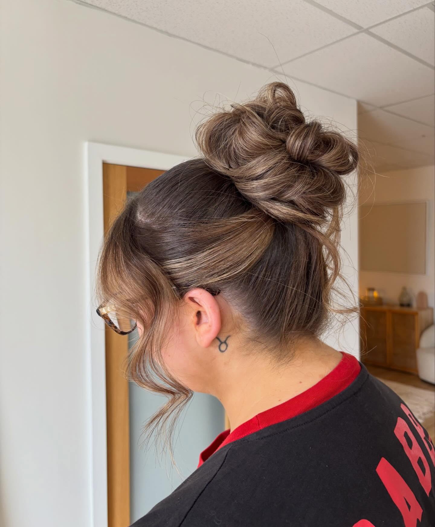 Textured High Loop Bun with Tapered Nape and Caramel Face-Framing