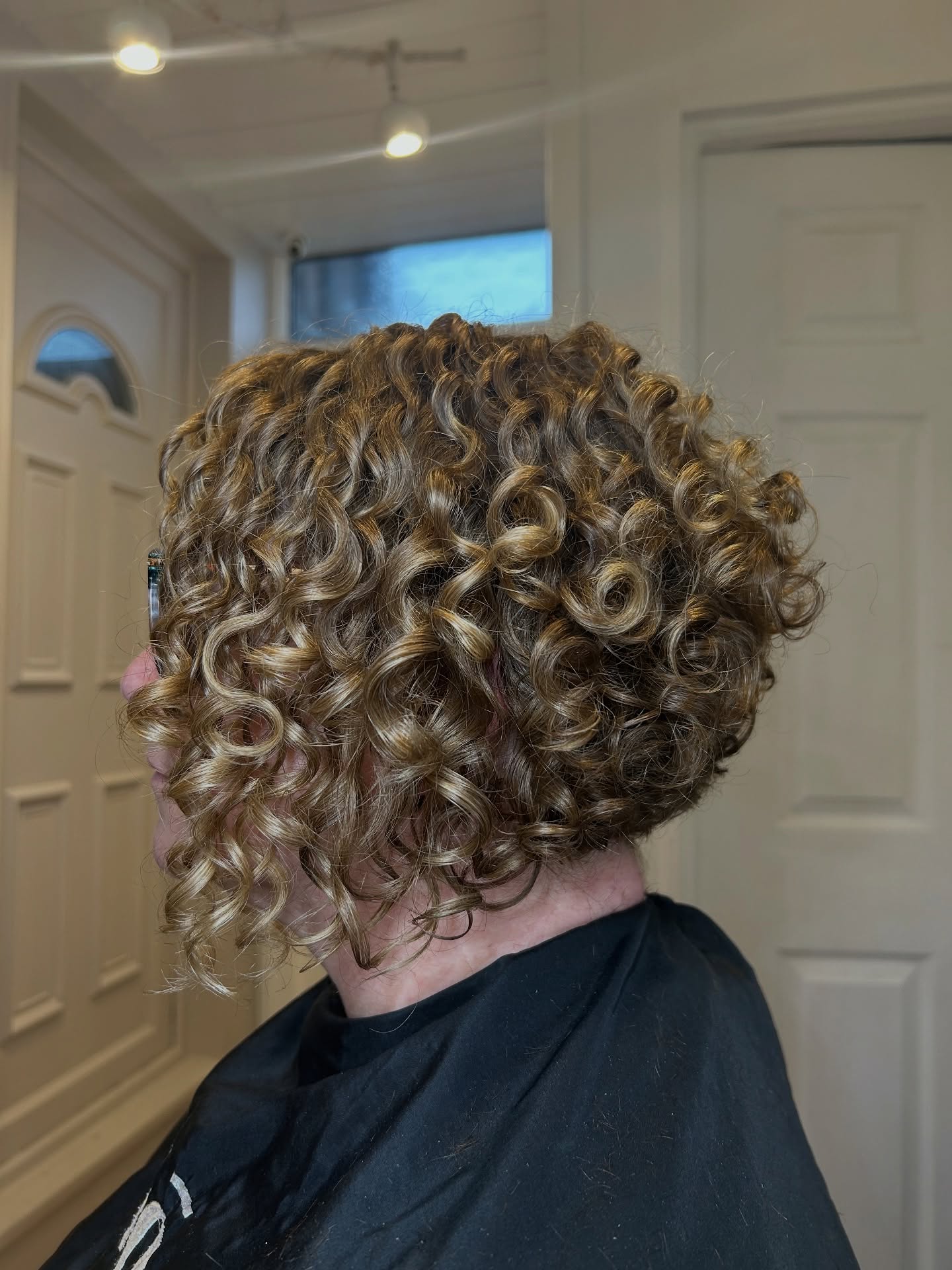 Tight Corkscrew Curly Stacked Bob with Golden Low Lights