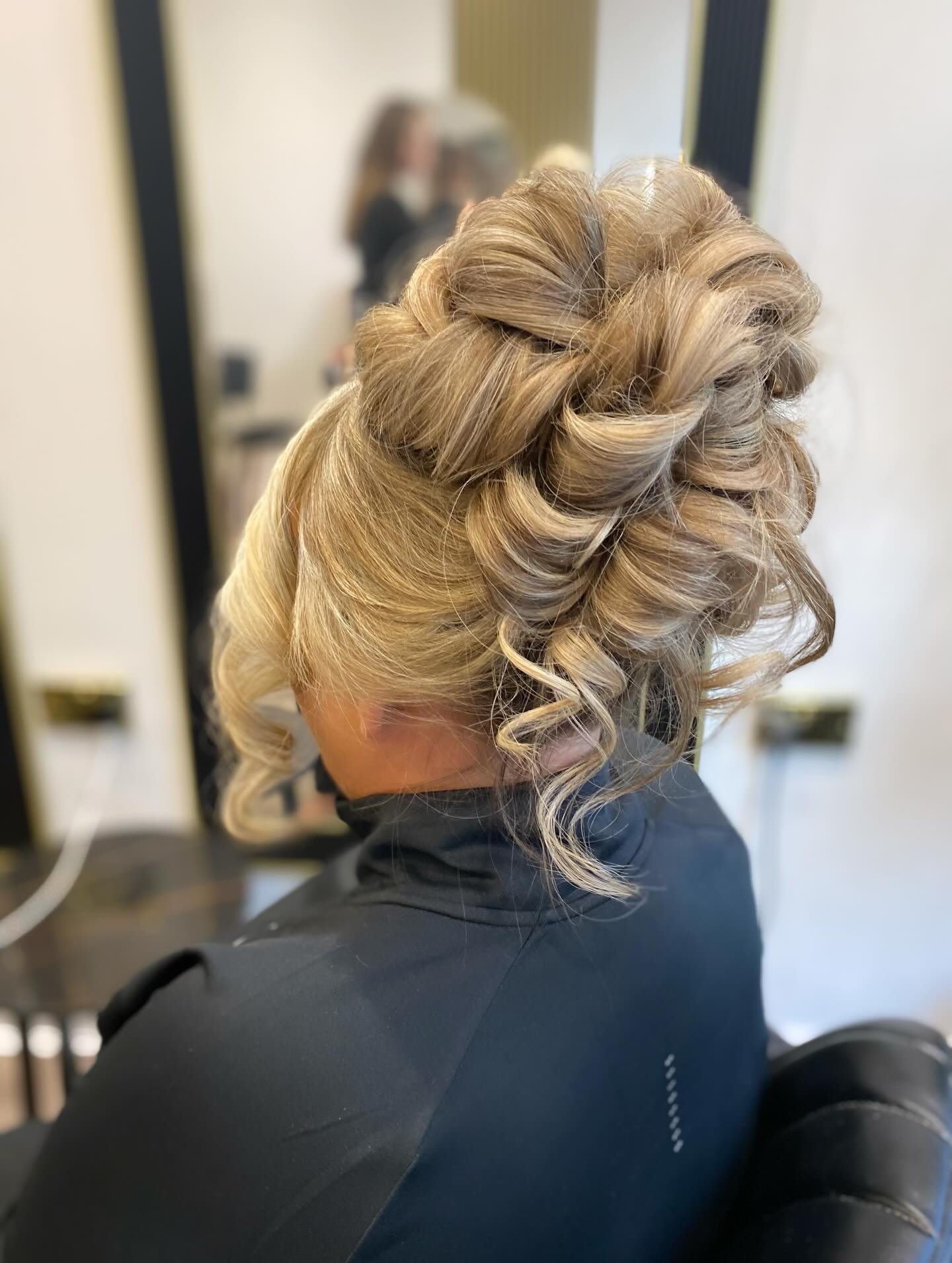 Voluminous Twisted Loop Updo with Ash-Blonde Dimension