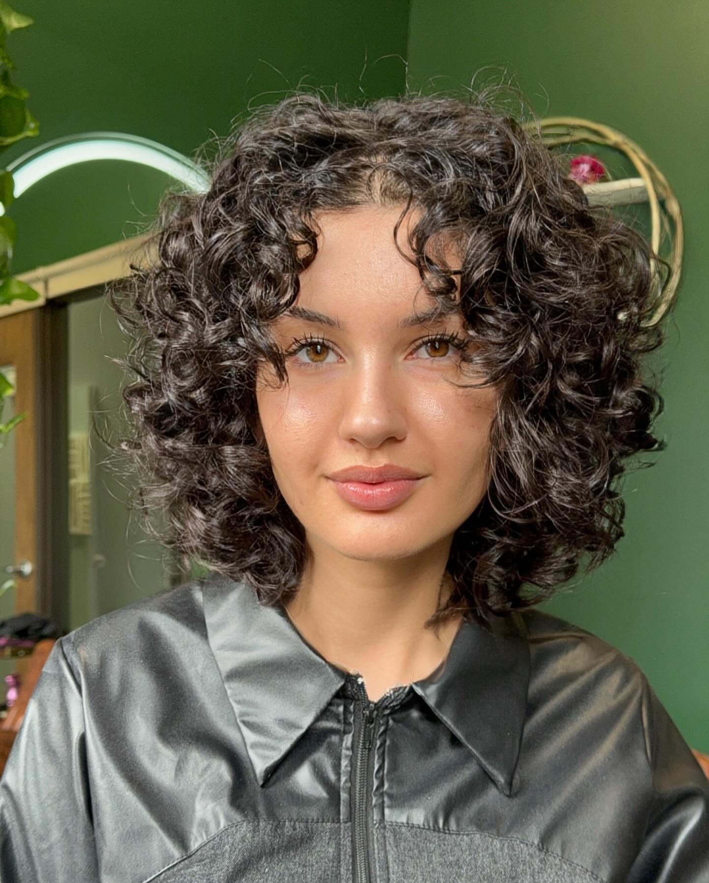 Rounded Curly Bob with Brow-Skimming Tendrils and Crown Lift