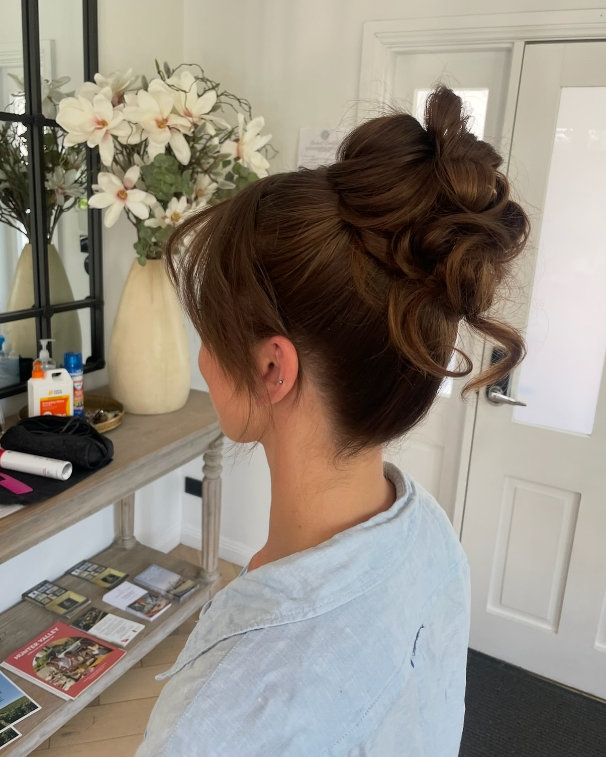 Voluminous Twisted High Bun with Face‑Framing Tendrils