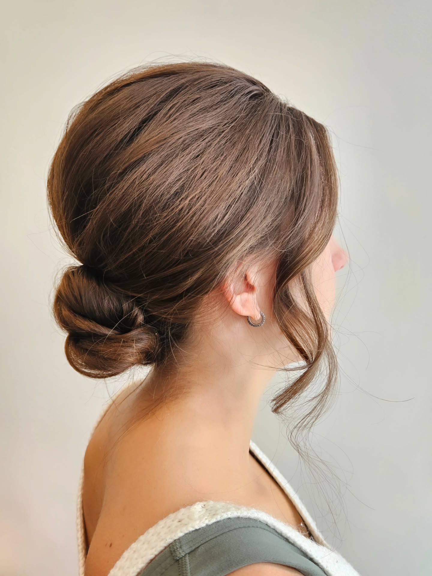 Low Twisted Tuck Chignon with Face-Framing Tendrils
