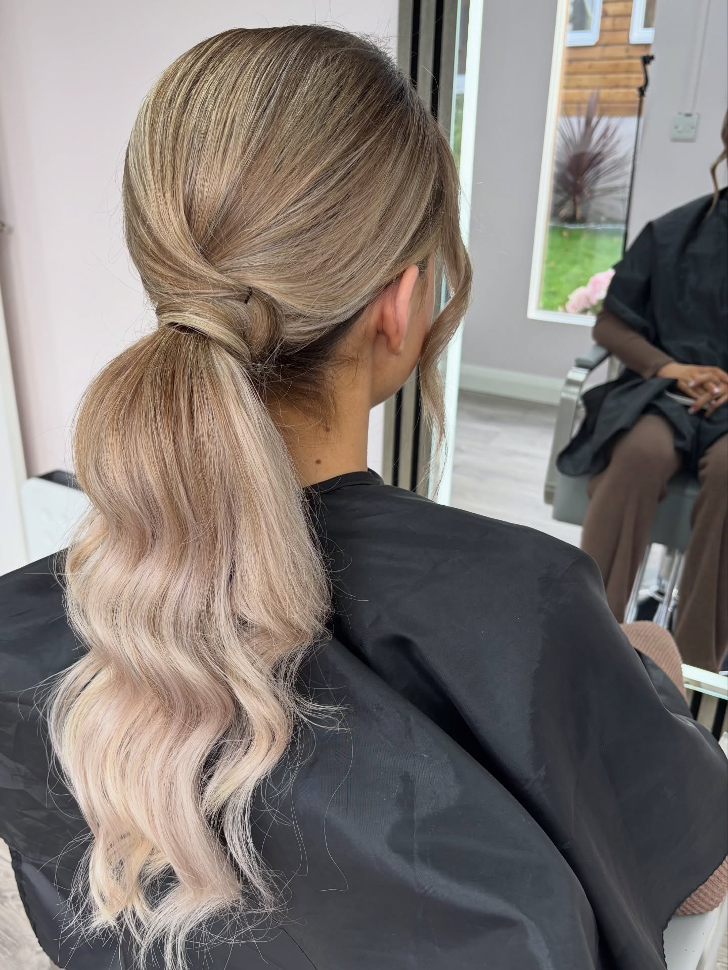 Low Wrapped Pony with Cool Ash-Blonde Balayage and Face-Framing Tendrils