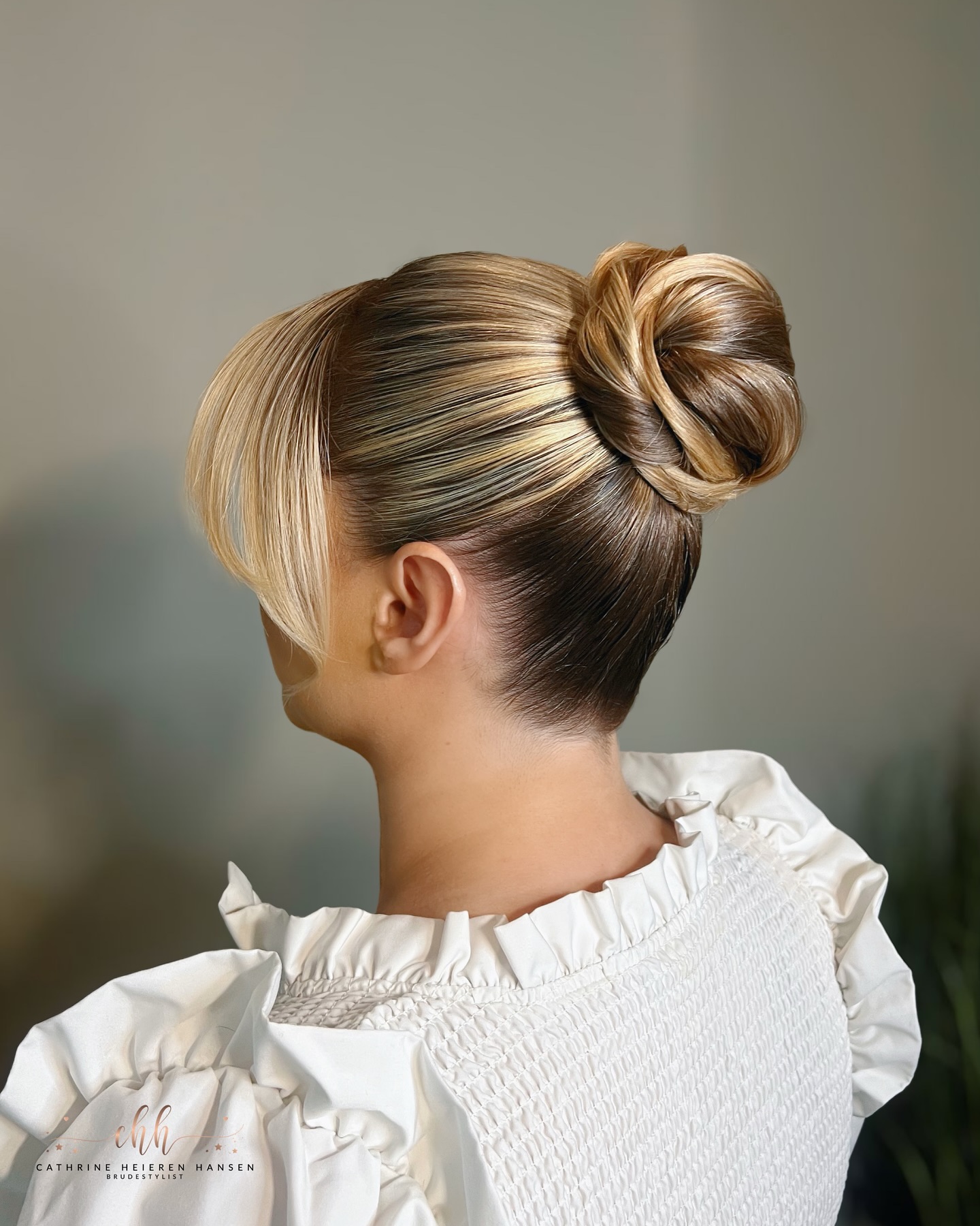 Sleek Twisted High Bun with Face-Framing Blonde Ribbon Highlights
