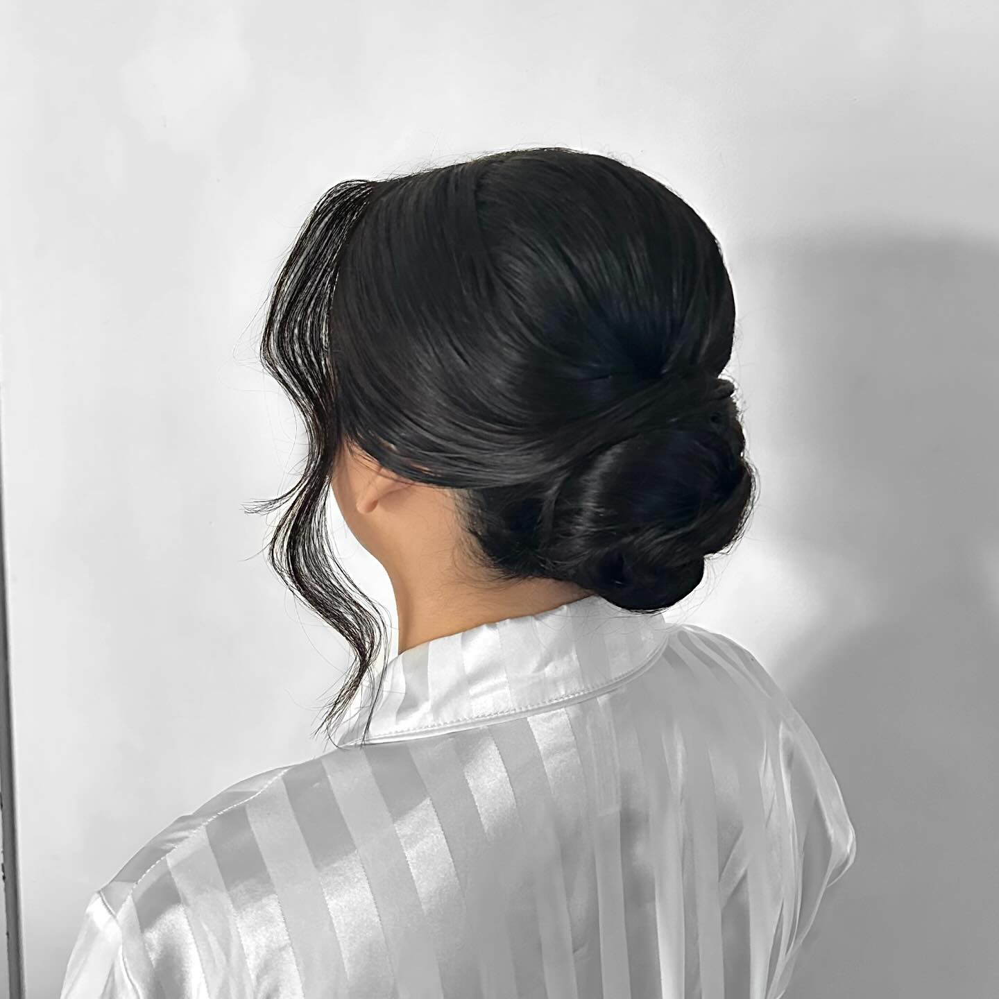 Sleek Low Knotted Chignon with Soft Curtain Tendrils